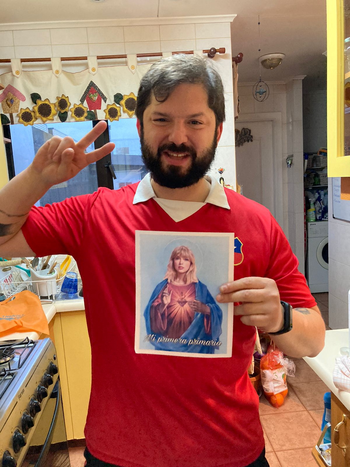 Una foto sin fecha del presidente electo de Chile, Gabriel Boric, posando con una imagen de la estrella del pop Taylor Swift (TWITTER/@swiftiesxboric/via REUTERS)