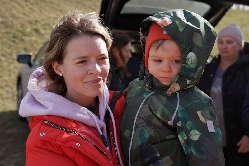 Svetlana, 28, una mujer ucraniana de Kiev, junto a su hijo Semyon mientras llegan a la ciudad fronteriza de Tiszabecs, Hungría, el 1 de marzo del 2022 en esta imágen tomada de un video. Gergely Papai/REUTERS TV via REUTERS