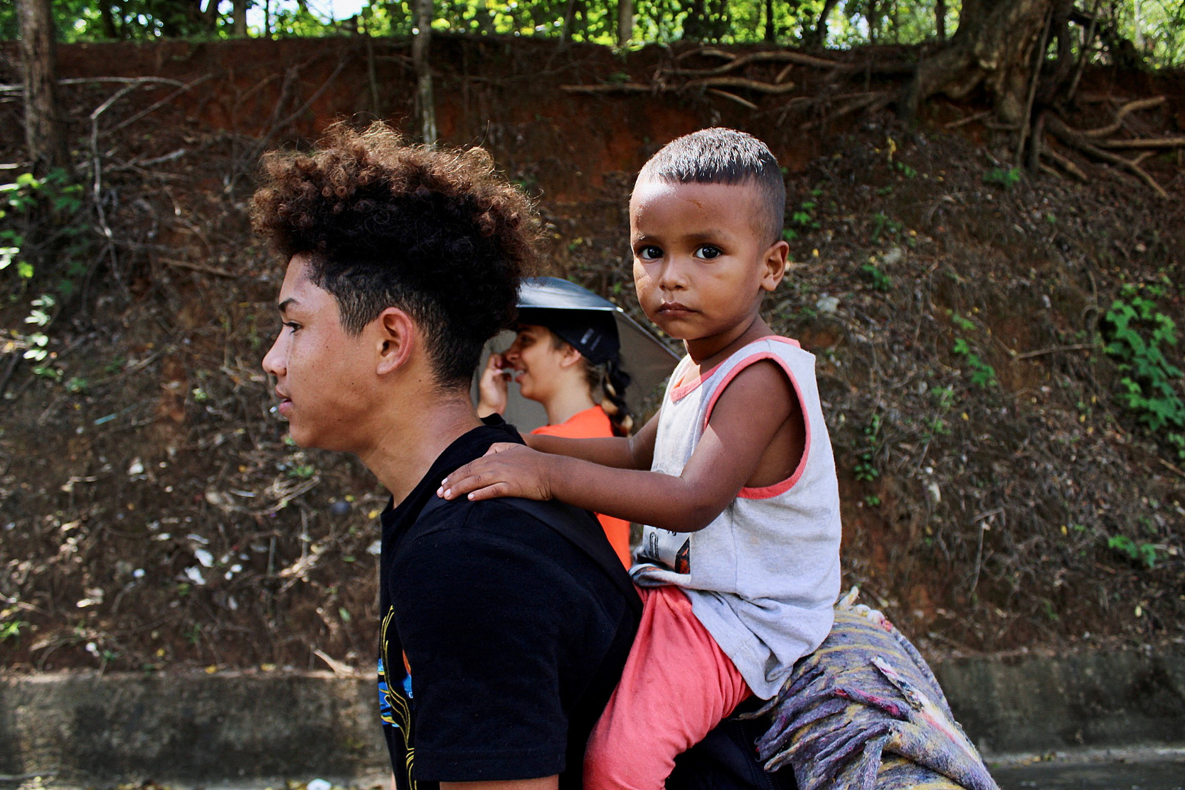 Un hombre carga a su hijo mientras camina junto con otros migrantes en una caravana por Tapachula (Foto: Reuters)