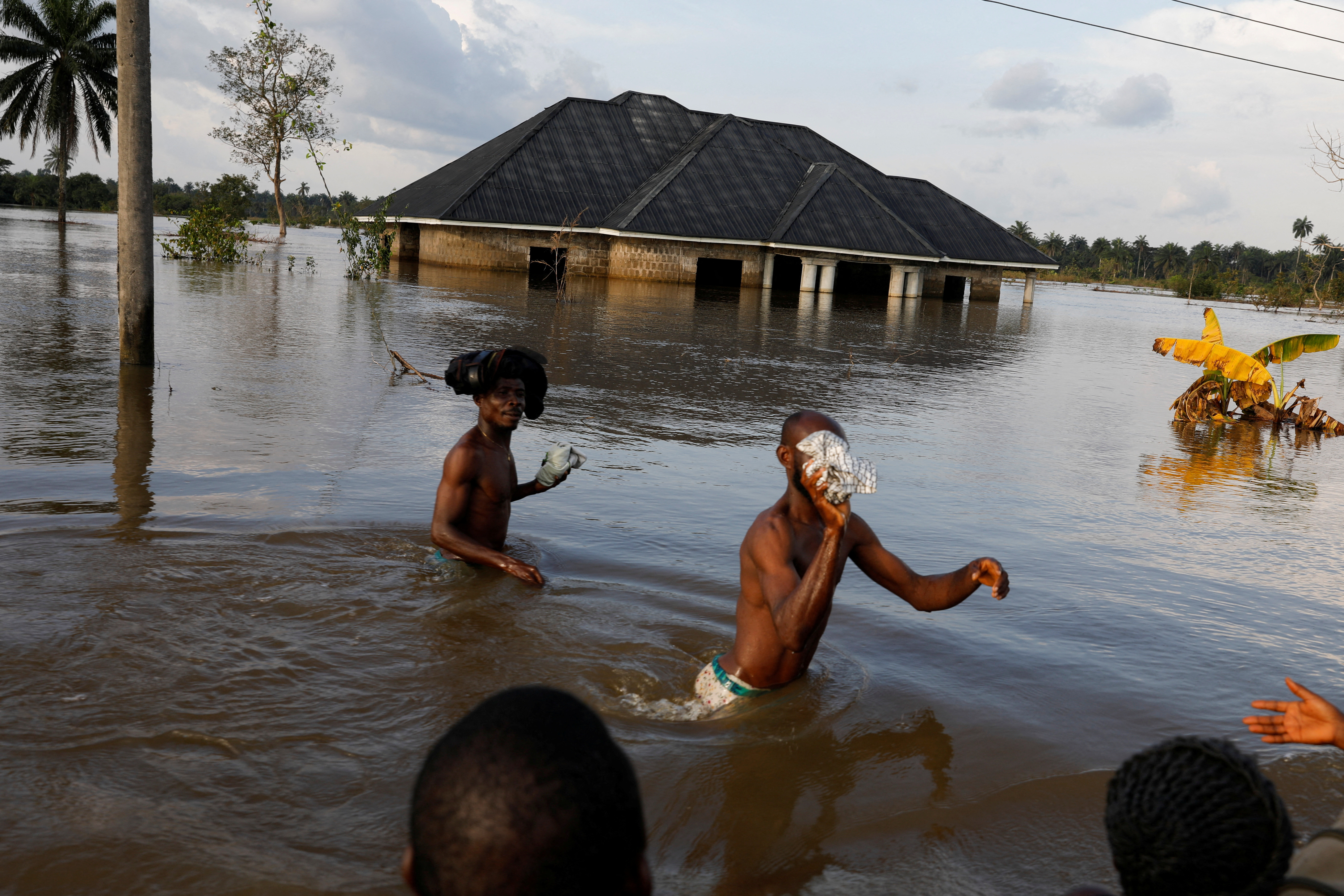 Los residentes atraviesan el agua después de una inundación masiva en la comunidad de Obagi, estado de Rivers, Nigeria, 22 de octubre de 2022. (REUTERS/Temilade Adelaja)