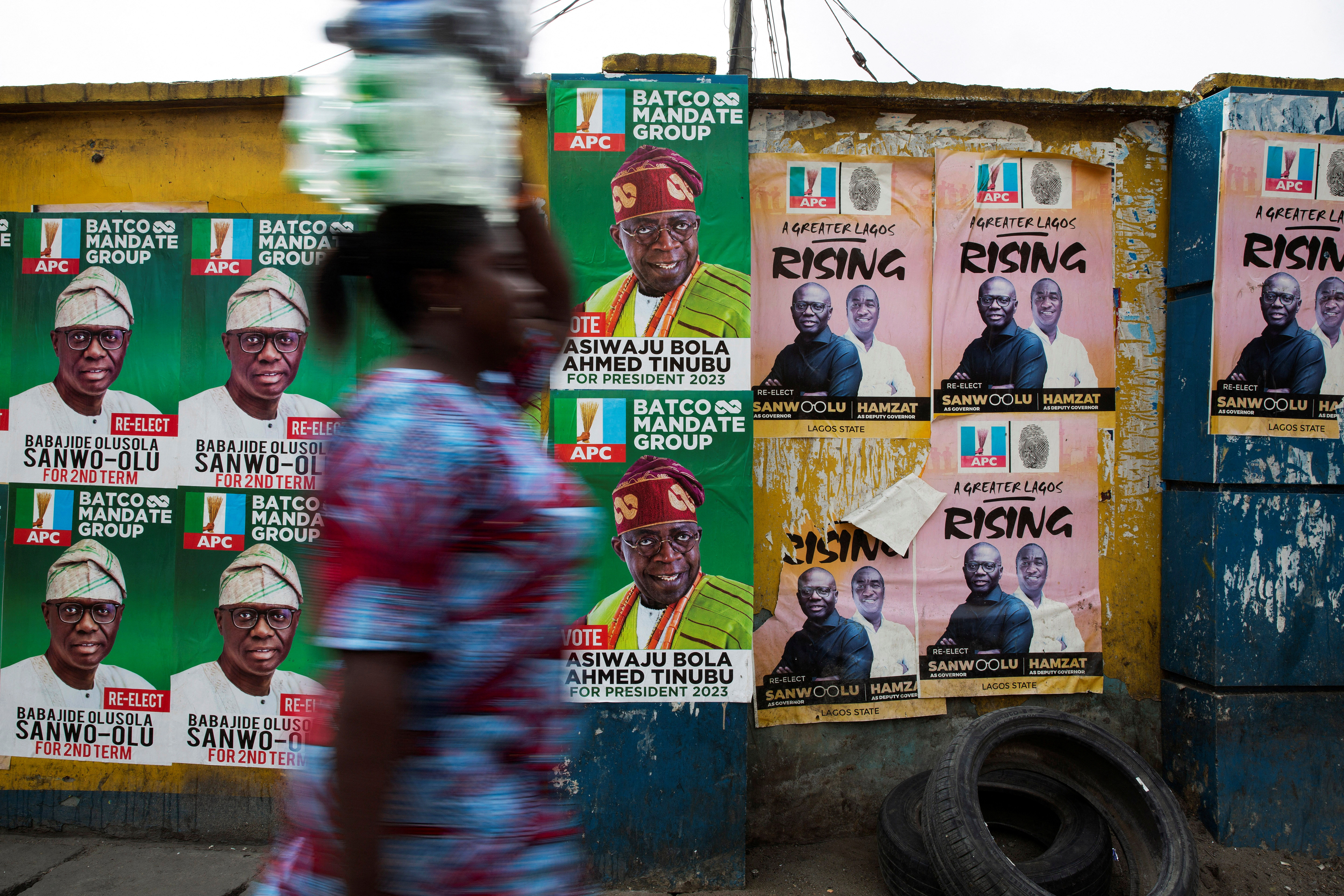 Una mujer pasa junto a los carteles electorales de los candidatos del partido APC en Lagos (REUTERS/James Oatway)