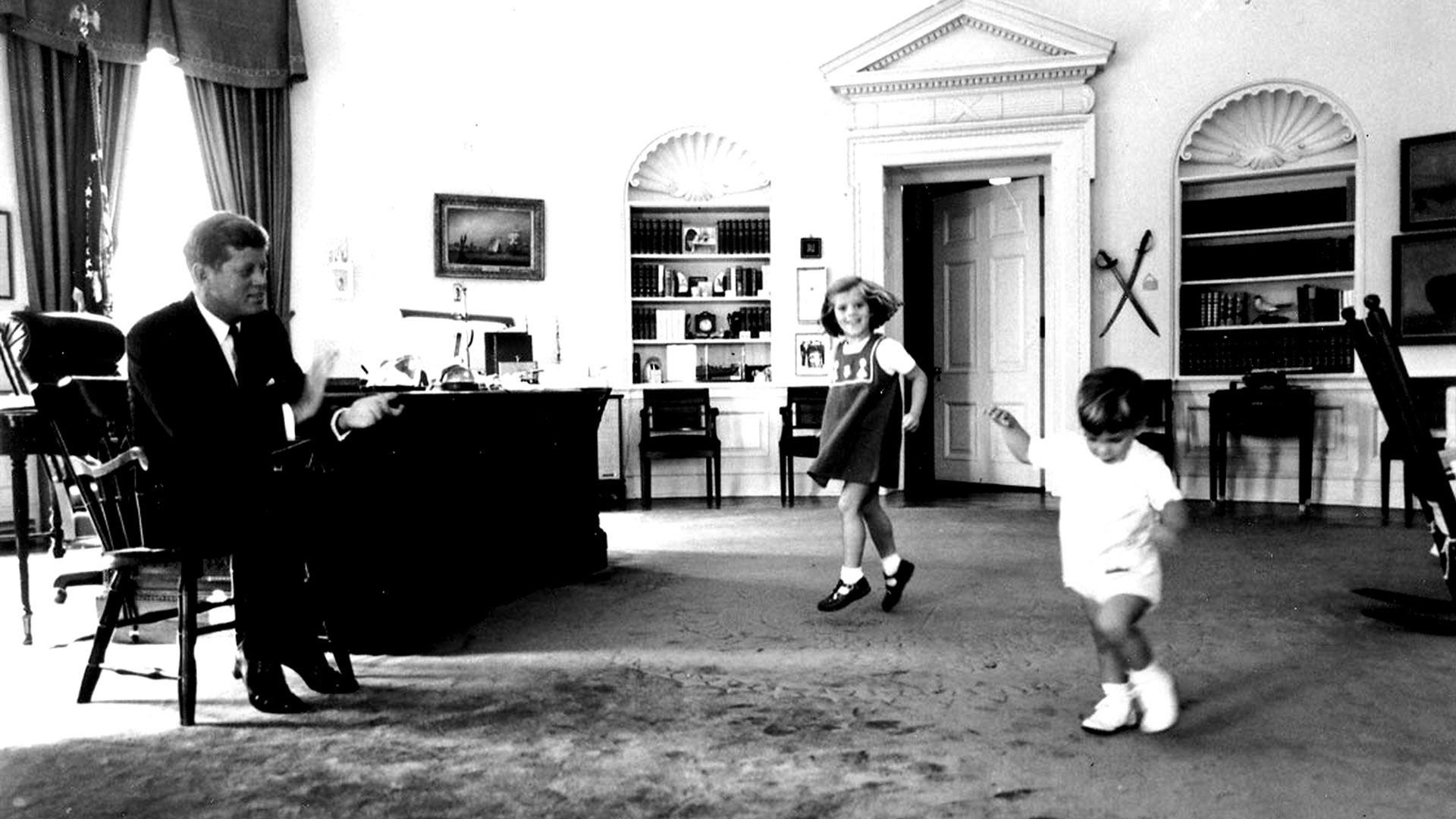 John Kennedy en el Salón Oval de la Casa Blanca con sus pequeños hijos John John y Carolina (Smith Collection/Gado/Getty Images).