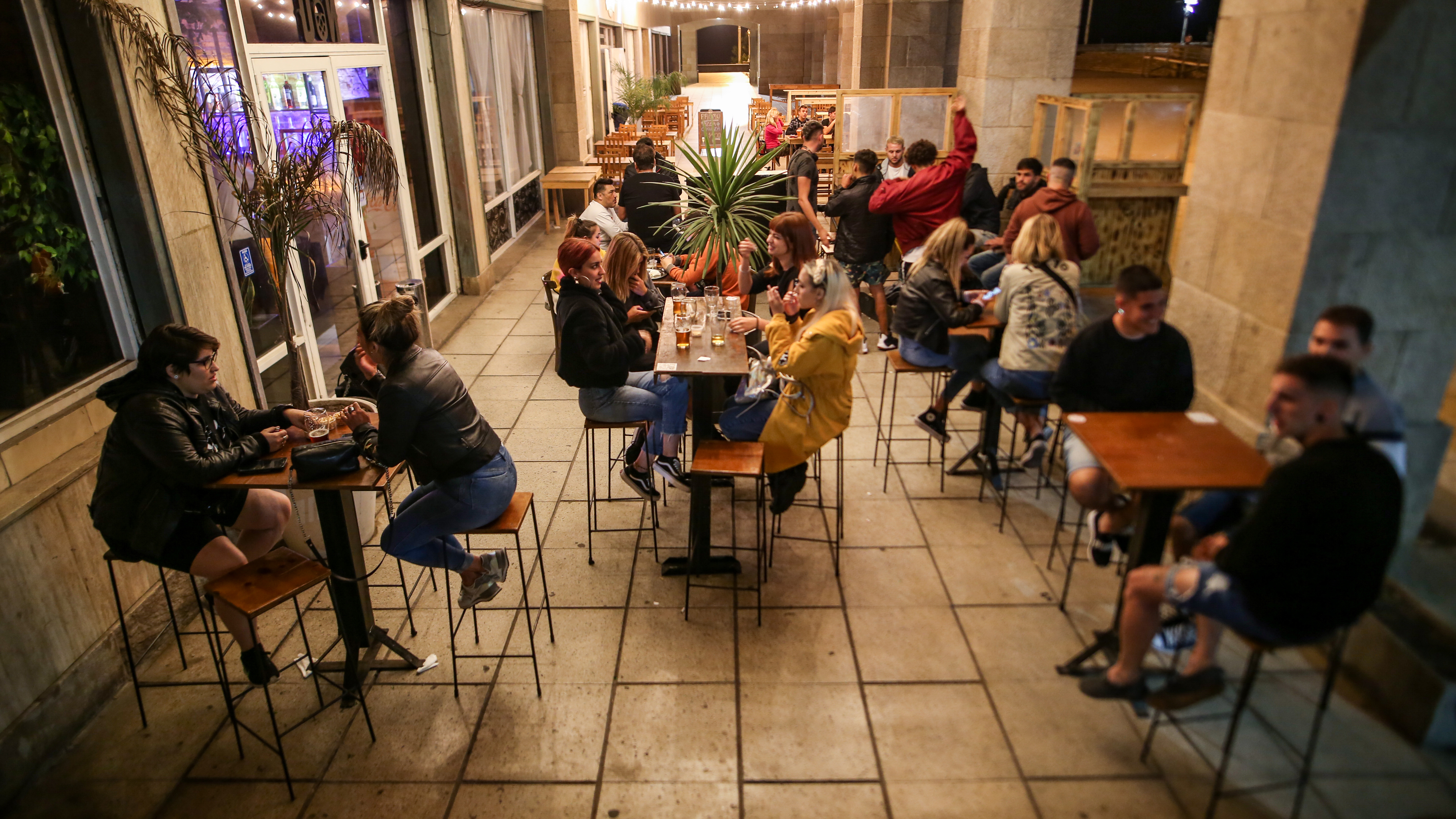 Frente a la rambla de Mar del Plata se respeta el distanciamiento al aire libre entre las mesas de una cervecería