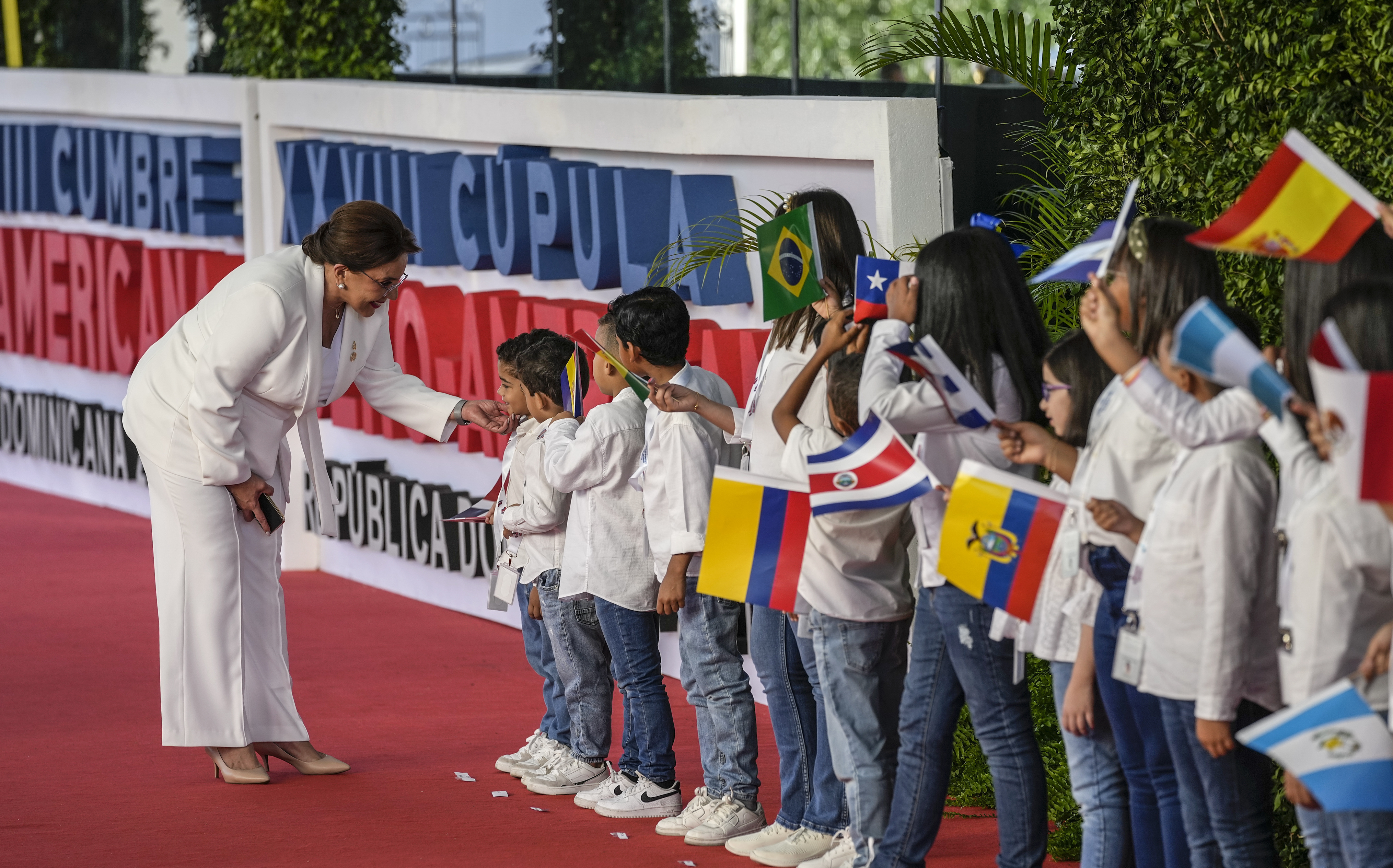 La presidenta de Honduras, Xiomara Castro, saluda a los niños a su llegada a la sesión de la 28ª Cumbre Iberoamericana, en Santo Domingo, República Dominicana, el sábado 25 de marzo de 2022. (Foto AP/Ariana Cubillos)