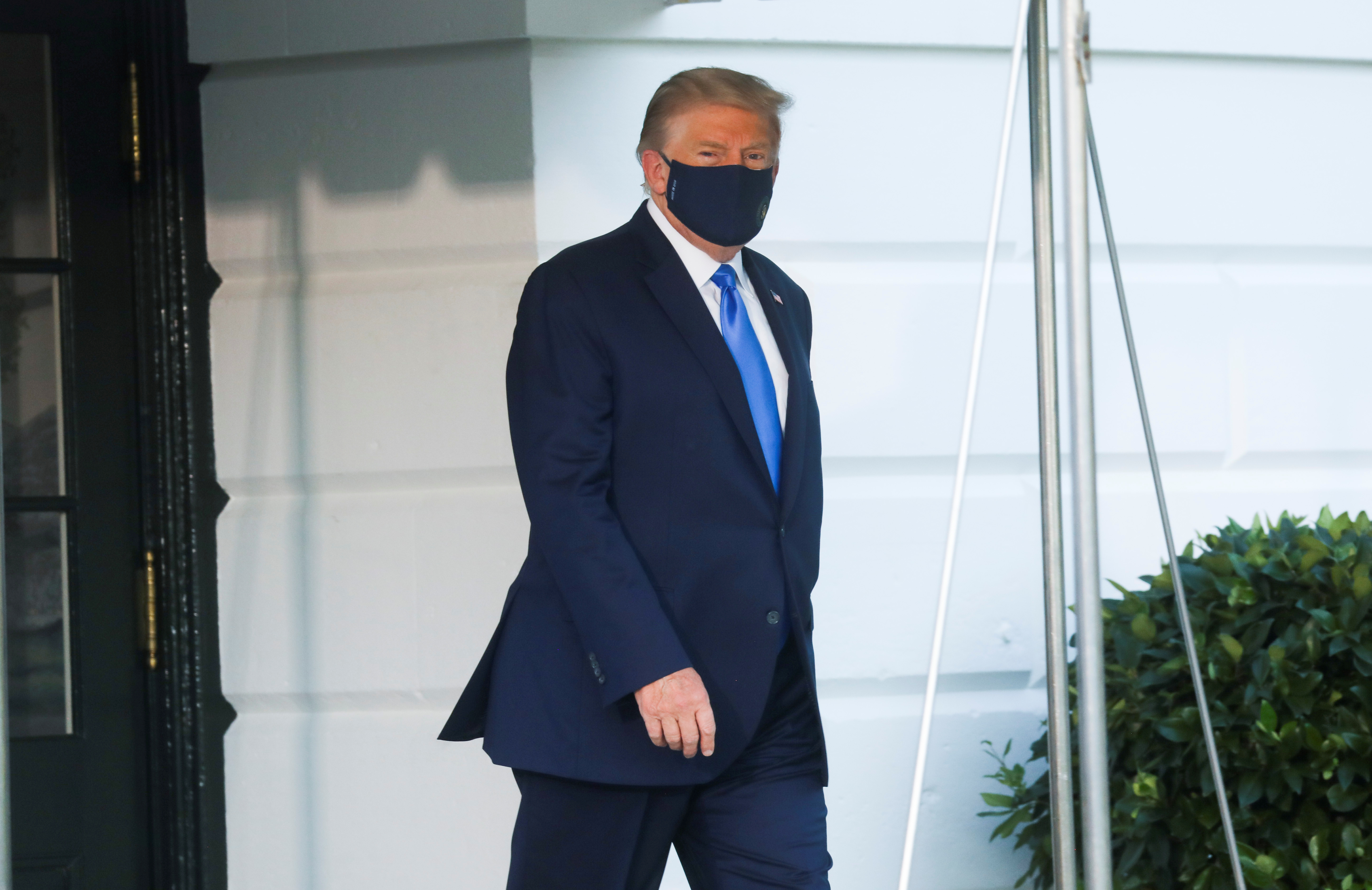 U.S. President Trump walks to the Marine One helicopter wearing a protective face mask as he departs the White House to fly to Walter Reed National Military Medical Center, where it was announced he will work for at least several days after testing positive for the coronavirus disease (COVID-19), on the South Lawn of the White House in Washington, U.S., October 2, 2020. REUTERS/Leah Millis