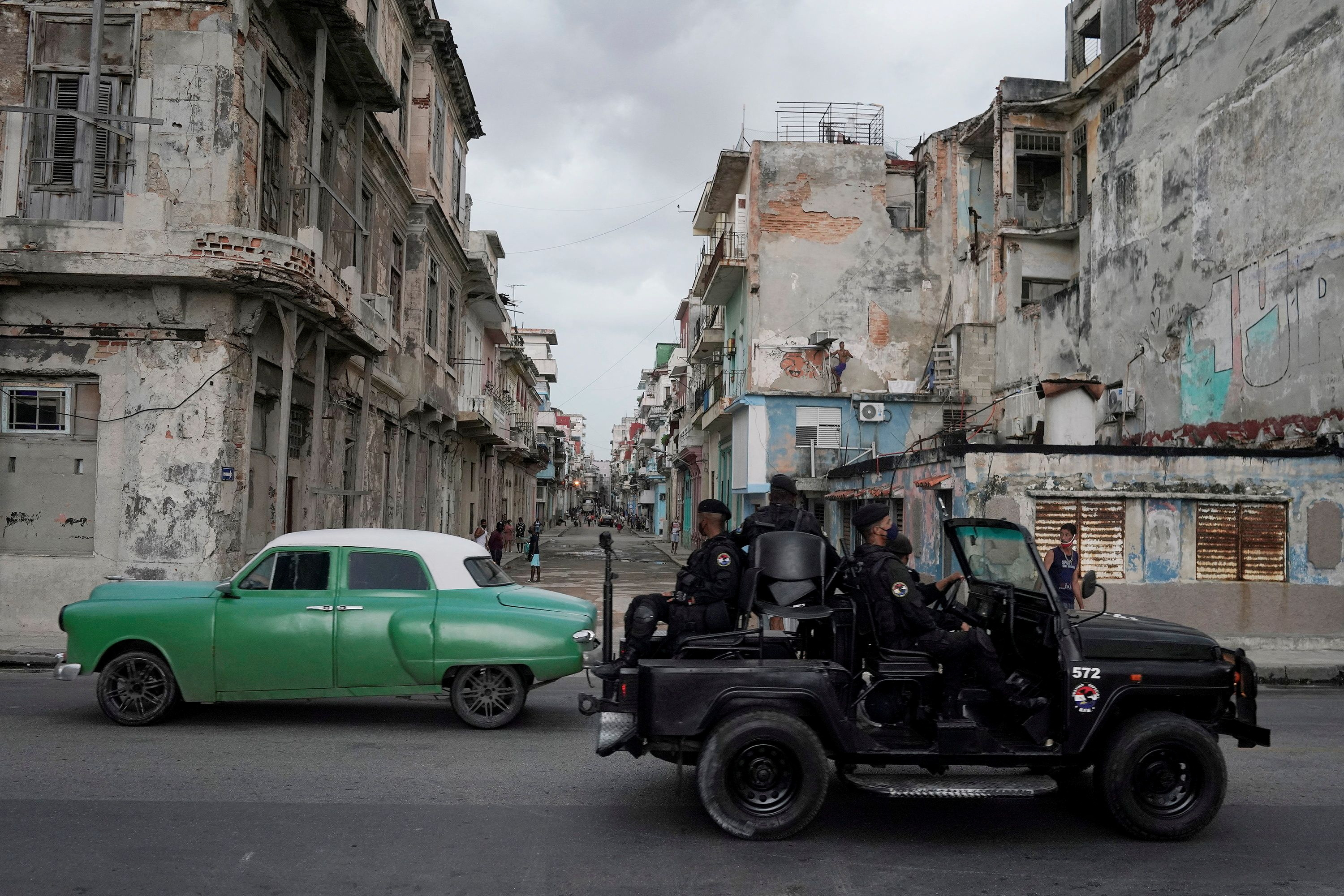 FOTO DEL FILE: Un veicolo delle forze speciali passa davanti a una vecchia auto nel centro dell'Avana, Cuba, il 13 luglio 2021. REUTERS/Alexandre Menegini/Foto del file