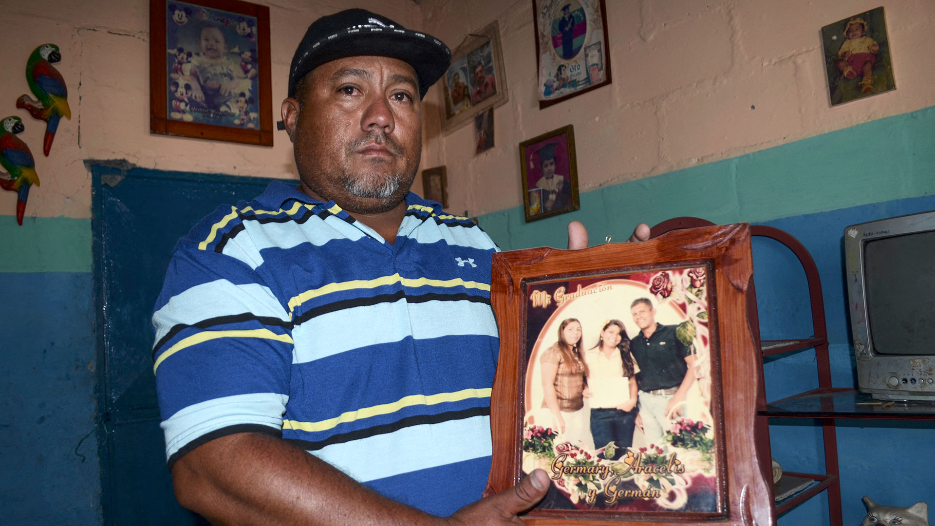 Alirio Yáñez muestra un retrato familiar de su hermano Germán Machado, una de las nueve personas que fallecieron tras beber alcohol adulterado en la comunidad de Chivacoa (Néstor VIVAS/AFP)