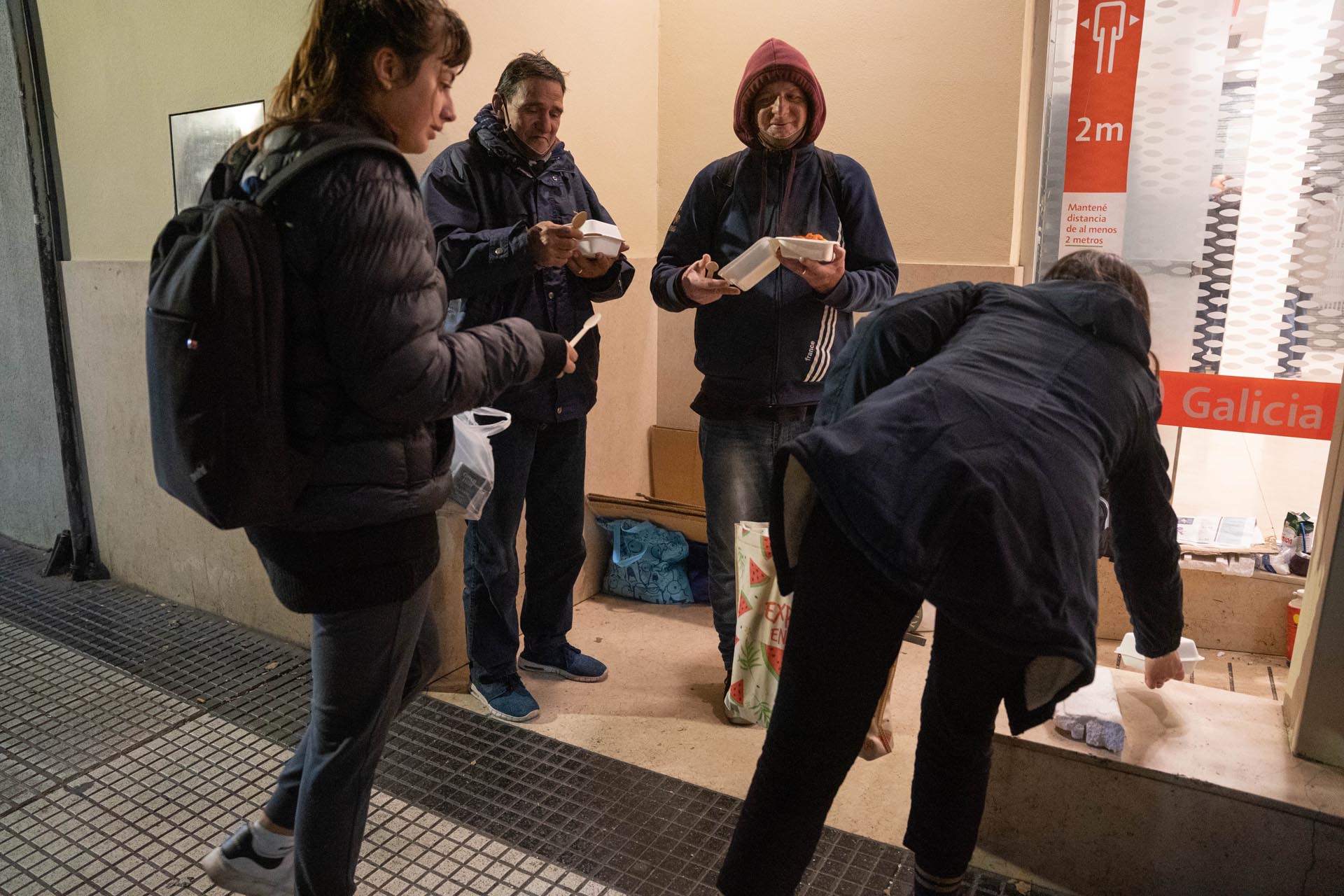 Voluntarios de la Fundación Si entregan comida a Rodolfo, Claudio y El Cordobés, tres personas en situación de calle