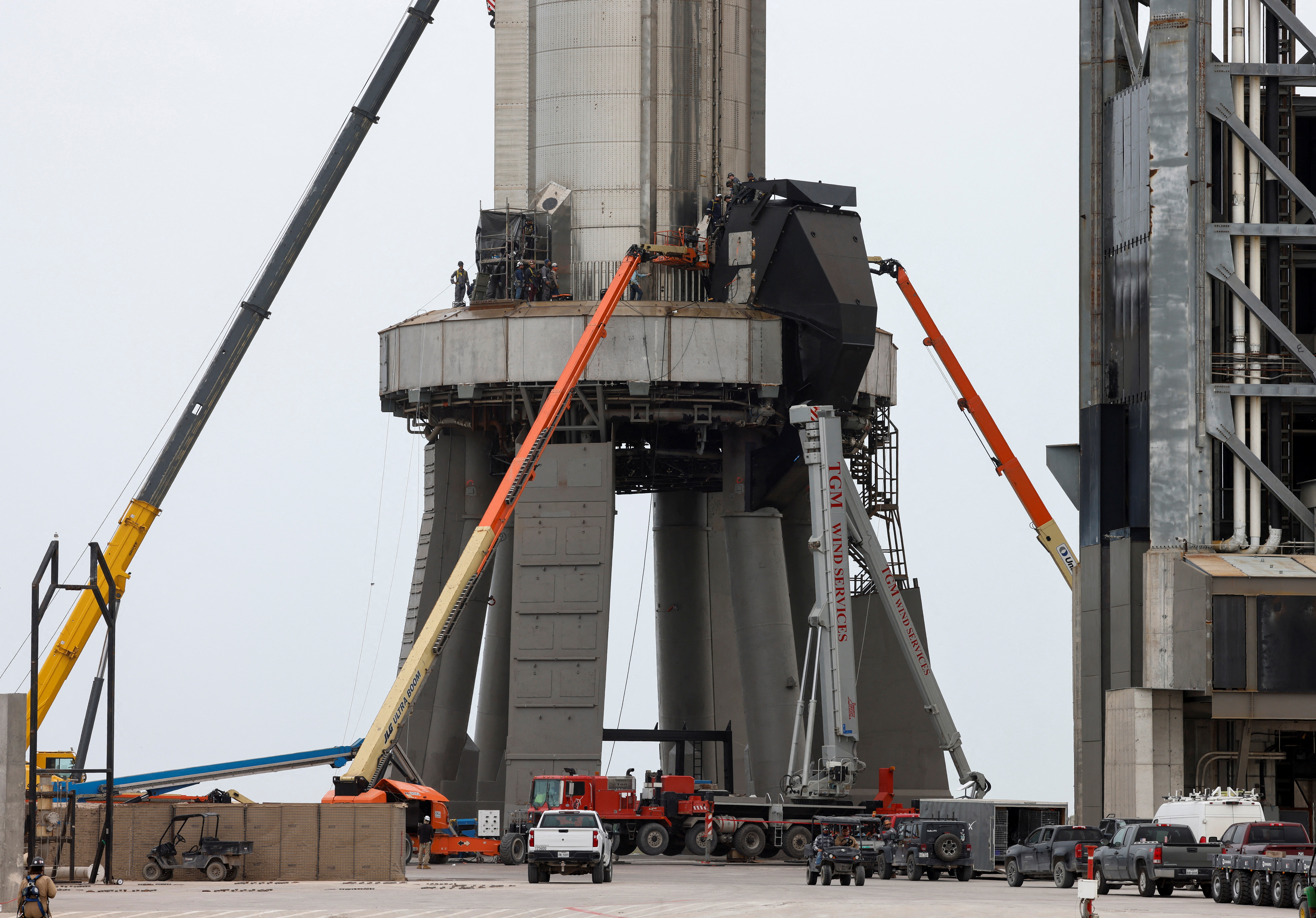Los trabajadores de SpaceX se muestran junto a Starship cerca de su plataforma de lanzamiento en Boca Chica (REUTERS/Joe Skipper)