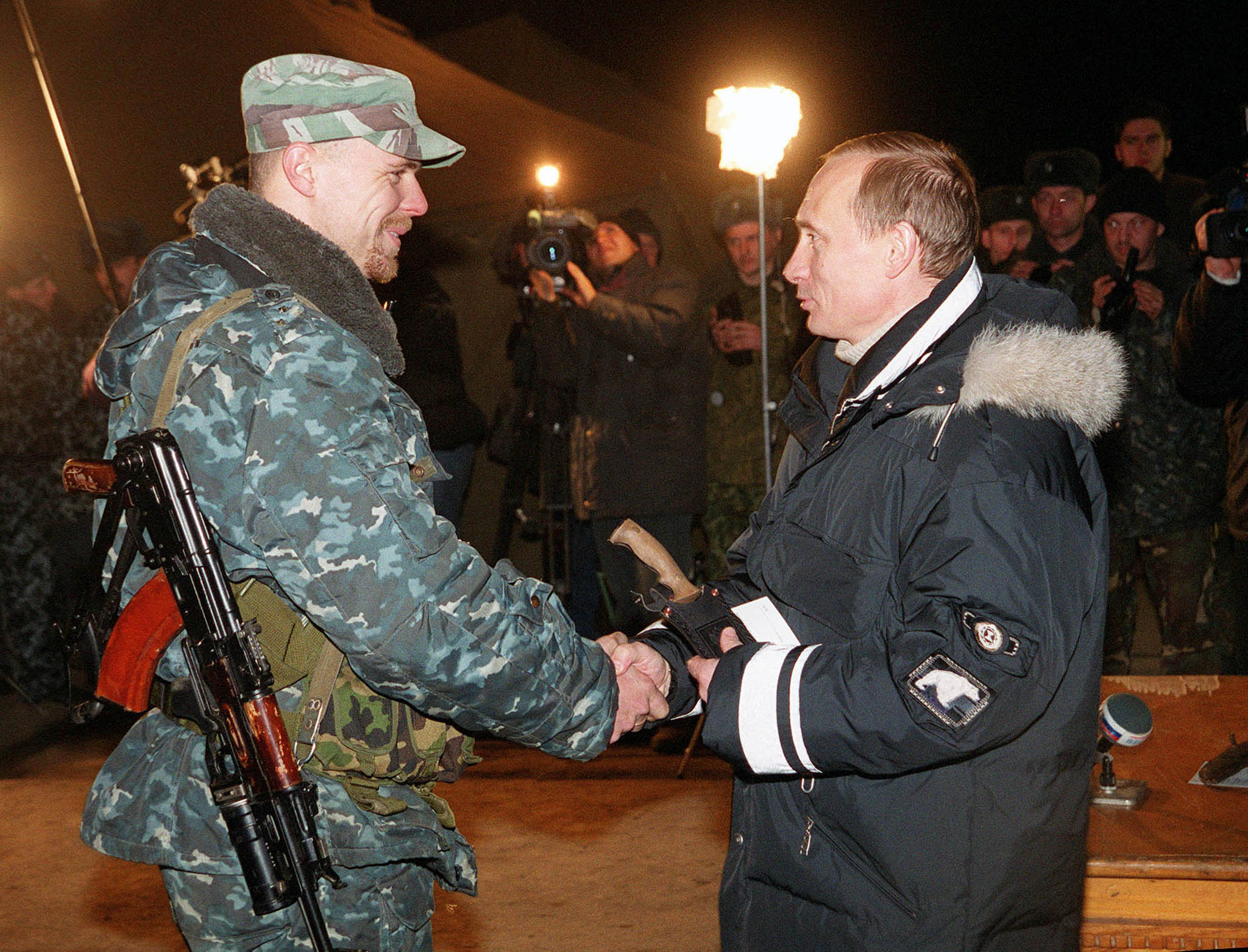El entonces presidente interino Vladimir Putin (der.) durante una visita a las fuerzas rusas en Chechenia para elogiarlos por la campaña para aplastar a los rebeldes separatistas, el 1 de enero de 2000. (REUTERS/Piscina/Foto de archivo)