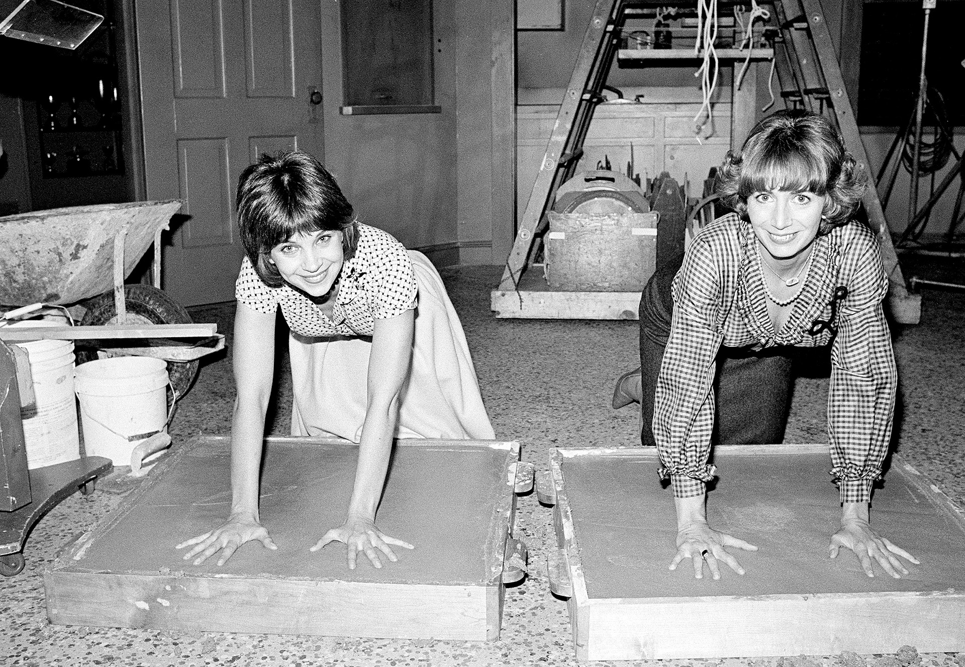 ARCHIVO - Las actrices Cindy Williams, a la izquierda, y Penny Marshall, estrellas de la serie de comedia de ABC-TV "Laverne and Shirley", dejan una huella en el cemento después de la grabación de su programa en Los Ángeles, el 14 de noviembre de 1979.  (AP Photo/Lennox McLendon, File)