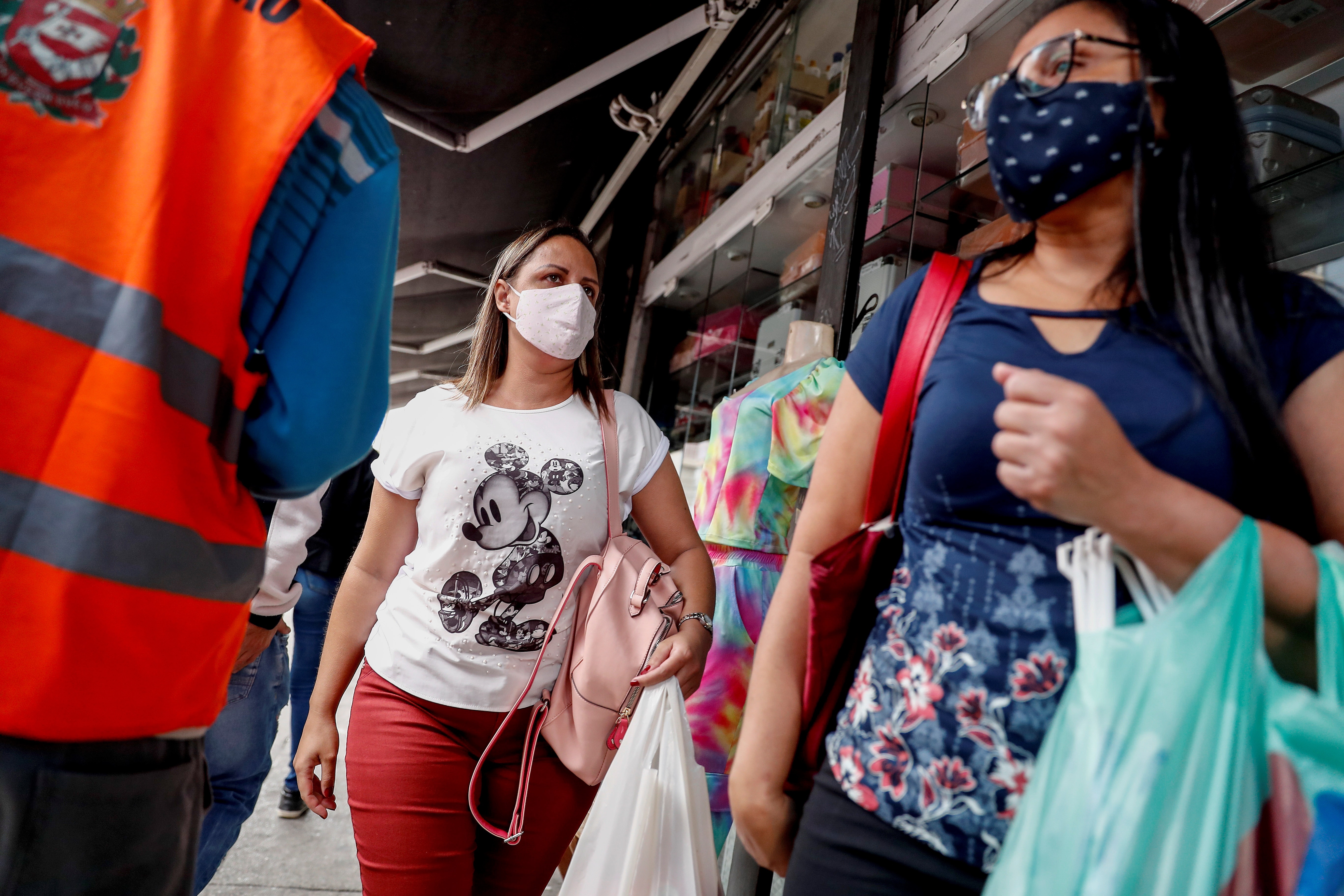 - Personas con tapabocas caminan hoy por un sector comercial de Sao Paulo (Brasil). EFE/ Sebastiao Moreira
