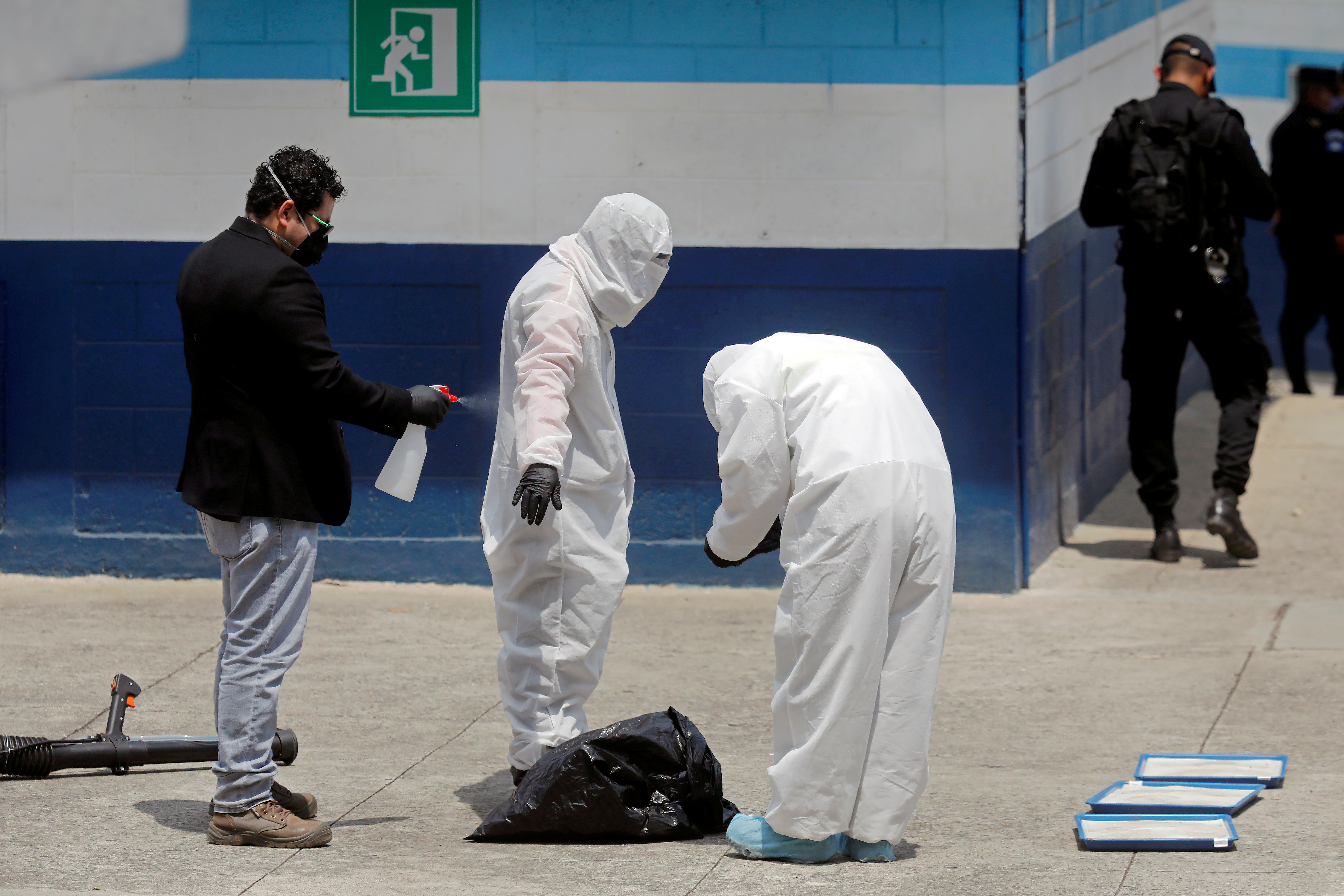 Personal del Ministerio de Salud de Guatemala, con trajes protectores y máscaras, se desinfectan en un refugio temporal para migrantes en la Ciudad de Guatemala, el 16 de abril de 2020 (REUTERS/Luis Echeverría/Foto de archivo)