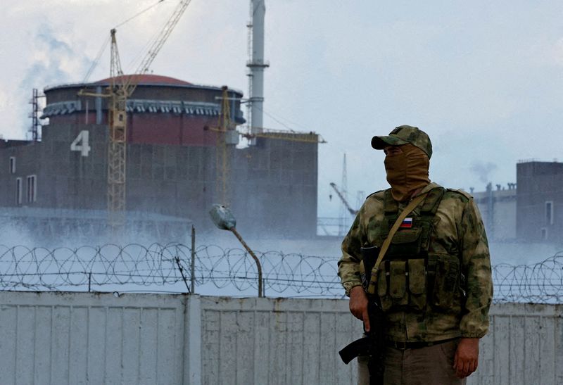 A man armed with the Russian flag on his uniform stands guard in front of the Zaporizhia nuclear power plant, outside Energodar, Zaporizhia region, Ukraine, on August 4, 2022. (REUTERS/Alexander Ermochenko)