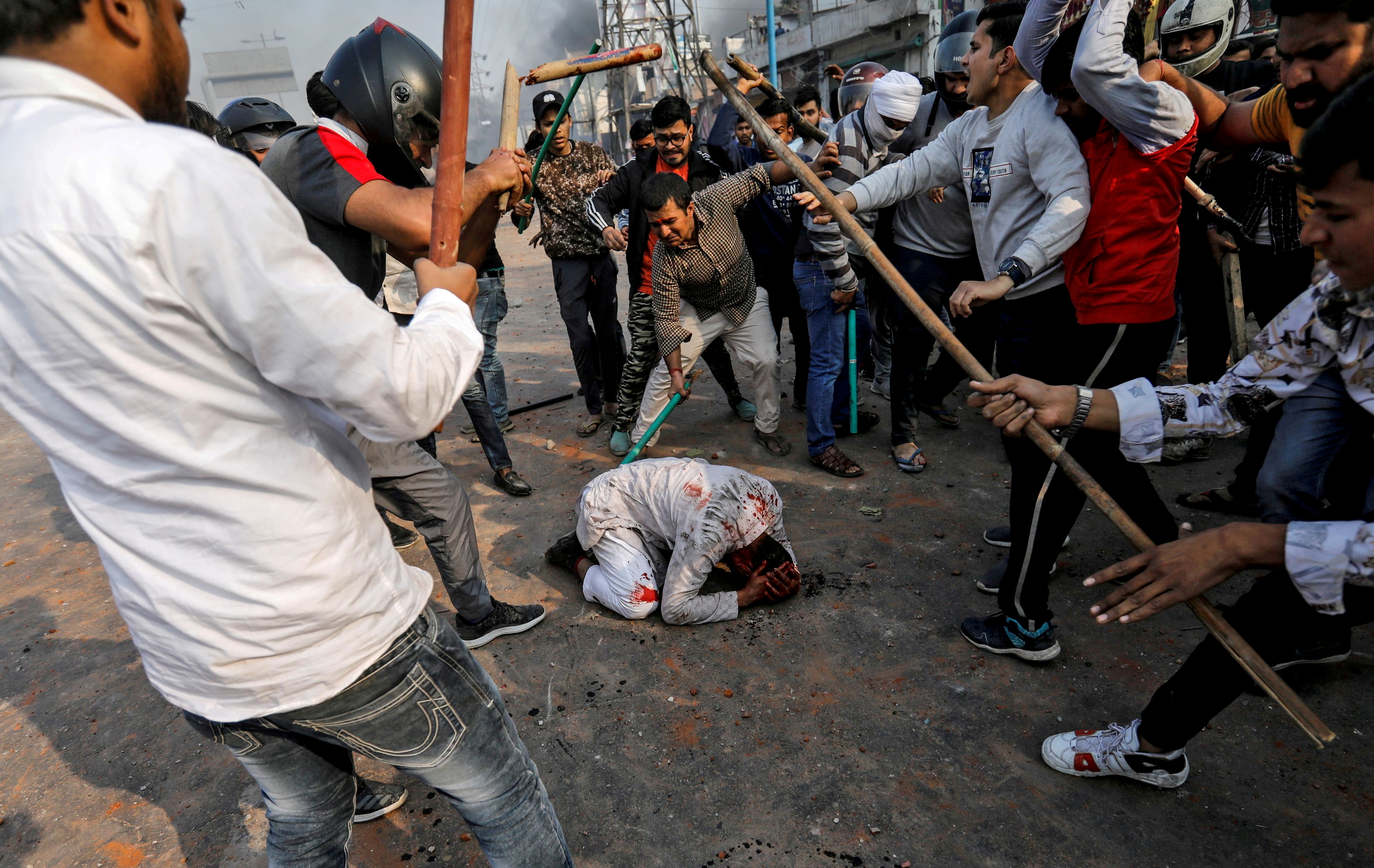 Un grupo de hombres que corean lemas pro-hindúes, golpean a Mohammad Zubair, de 37 años, que es musulmán, durante las protestas provocadas por una nueva ley de ciudadanía en Nueva Delhi, India, 24 de febrero de 2020. 