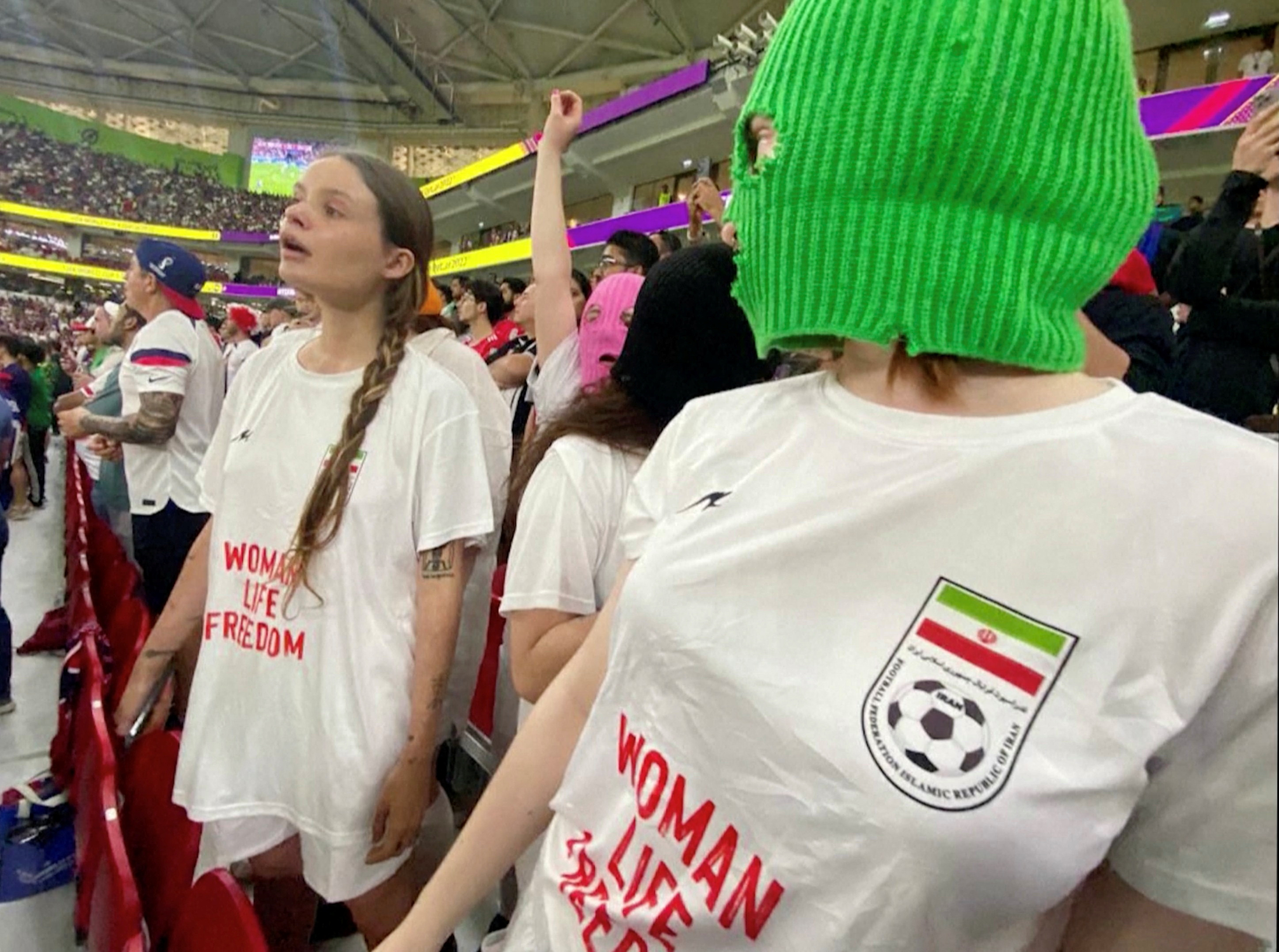 Las Pussy Riot en el Mundial Qatar 2022. Durante el partido Irán-Estados Unidos, vistieron remeras en solidaridad con las mujeres iraníes (Foto: Cinema for Peace Foundation/Handout via REUTERS)
