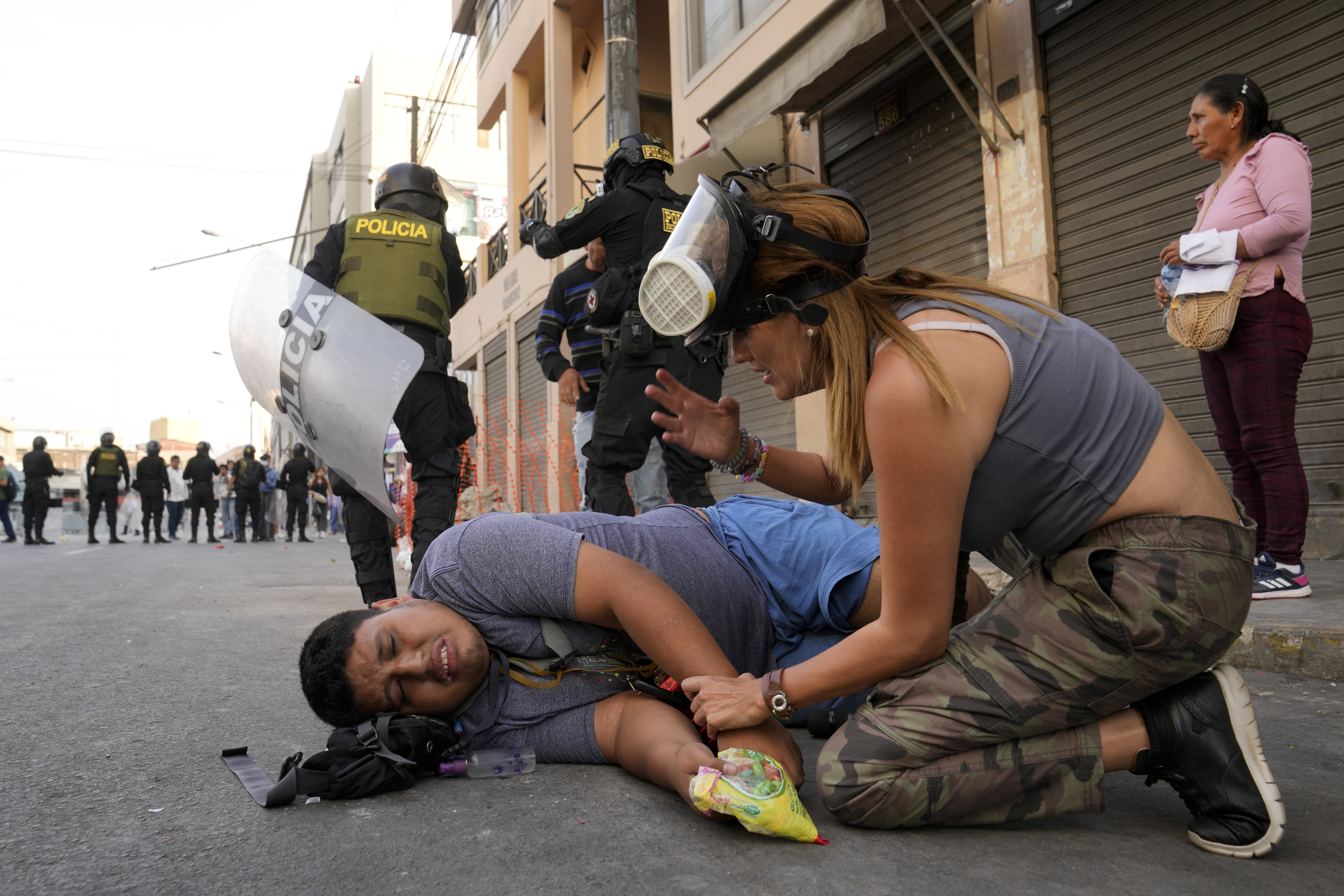 Una mujer atiende a un manifestante que cayó al suelo durante la marcha. (AP Foto/Martín Mejía)
