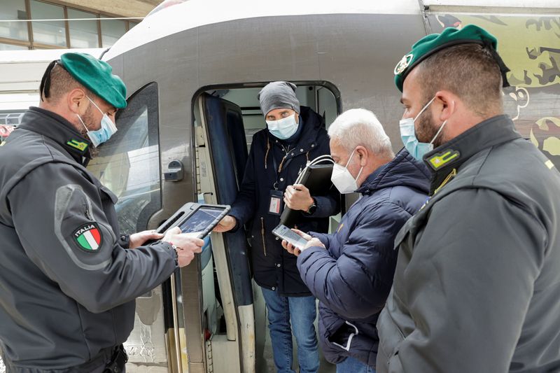 Agentes de la Guardia di Finanza comprueban el pase sanitario de un viajero de tren en Nápoles, Italia. 6 diciembre 2021. REUTERS/Ciro de Luca