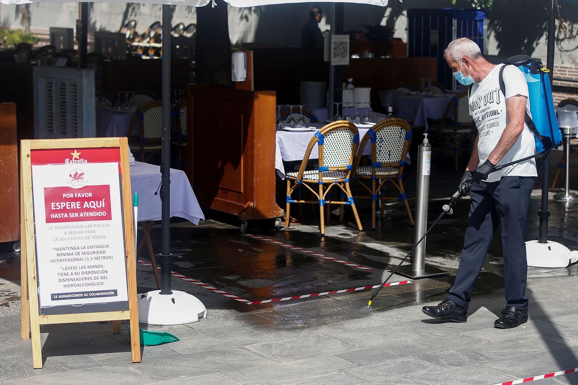 Un trabajador desinfecta la terraza de un bar en la Barceloneta. (EFE/Quique Garcia)