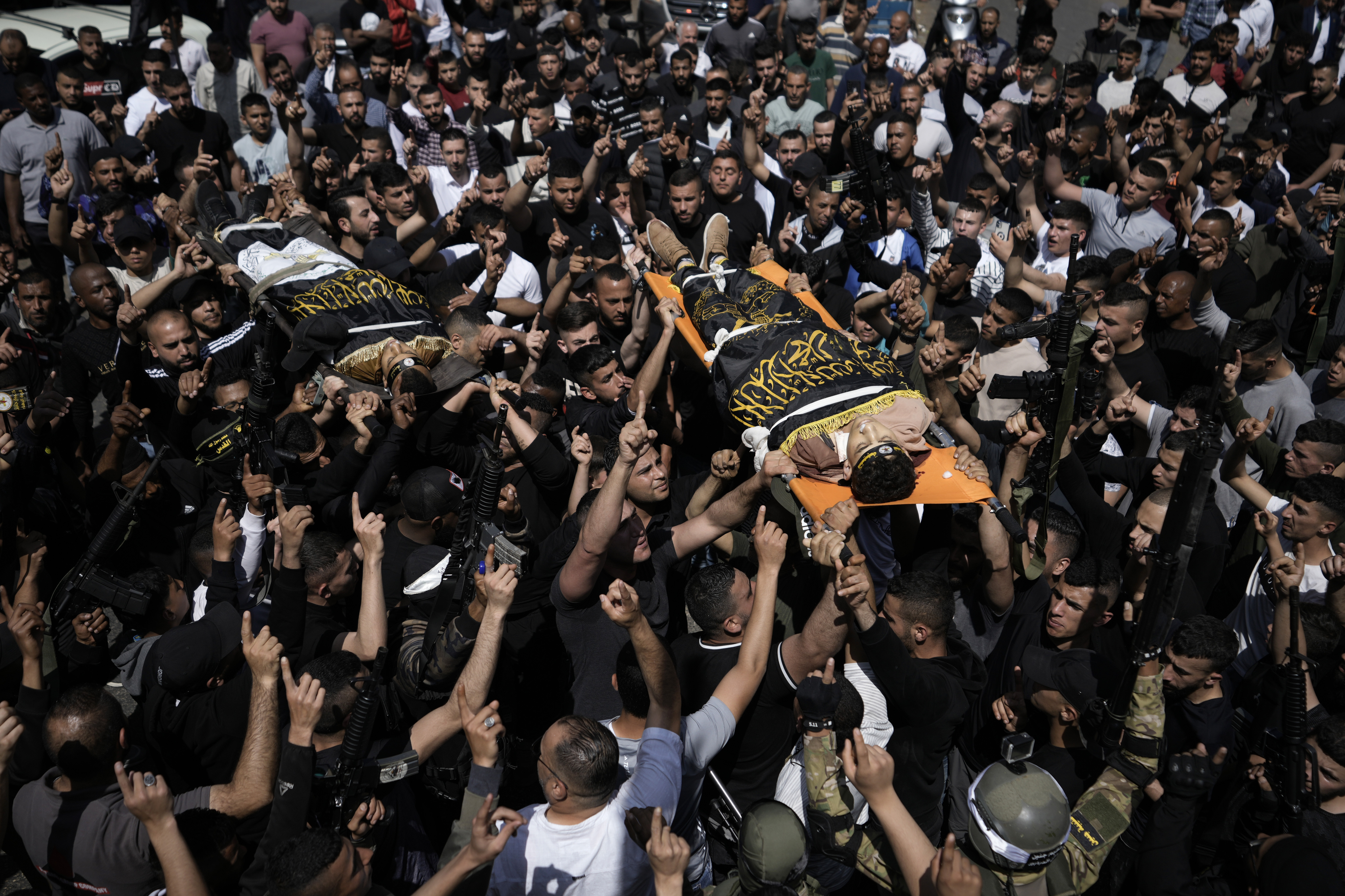 Una multitud traslada los cadáveres de Ahmed Assaf, de 19 años (derecha), y Rani Qatanat, de 24, envueltos en la bandera del grupo Yihad Islámica, dos palestinos asesinados por las fuerzas israelíes en Qabatiya, cerca de la ciudad cisjordana de Yenín, el 10 de mayo de 2023. (AP Foto/Majdi Mohammed)