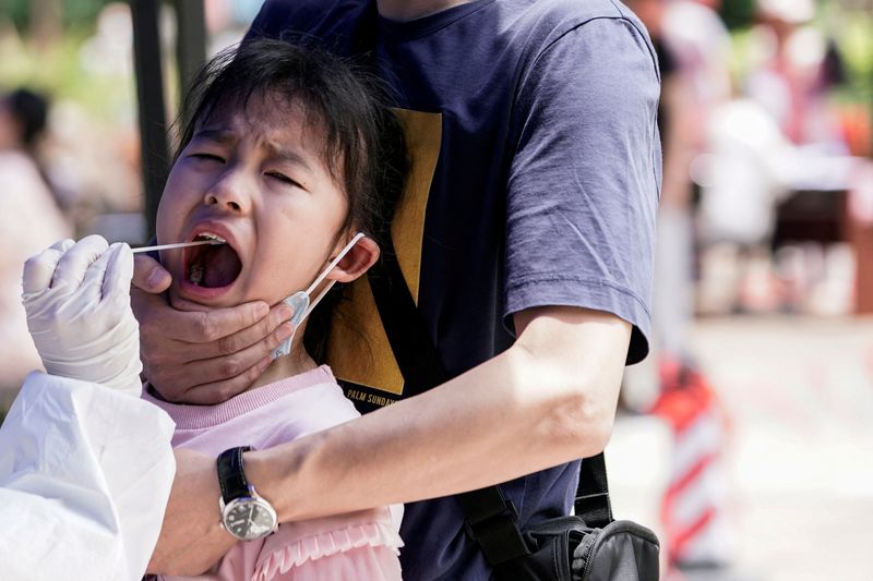 Una niña reacciona mientras se somete a una prueba de ácido nucleico en Wuhan, la ciudad china más afectada por el brote de la enfermedad por coronavirus (COVID-19), provincia de Hubei. REUTERS/Aly Song/Archivo