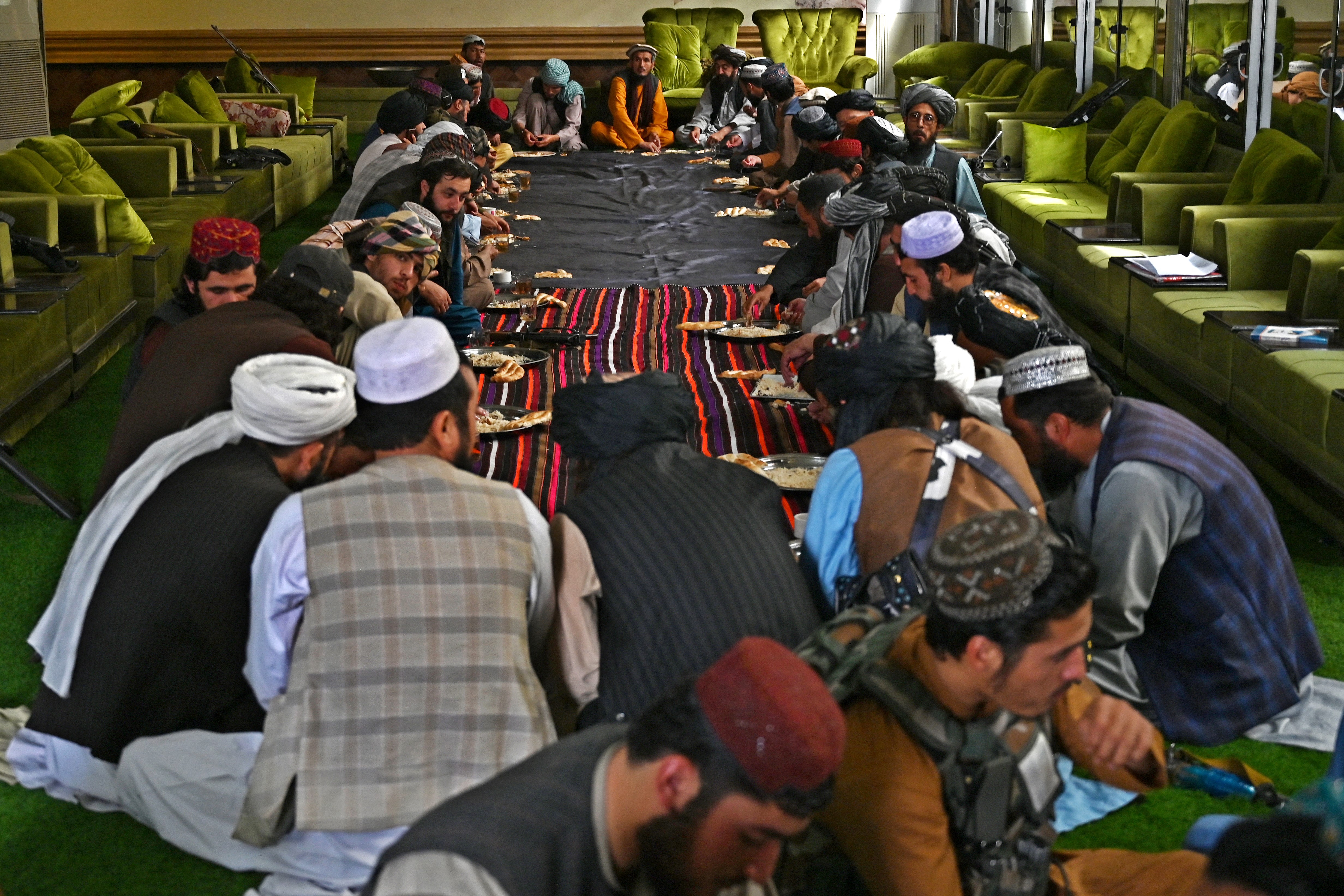 Militantes talibanes y curiosos en una de las salas de la mansión (Wakil KOHSAR / AFP) 