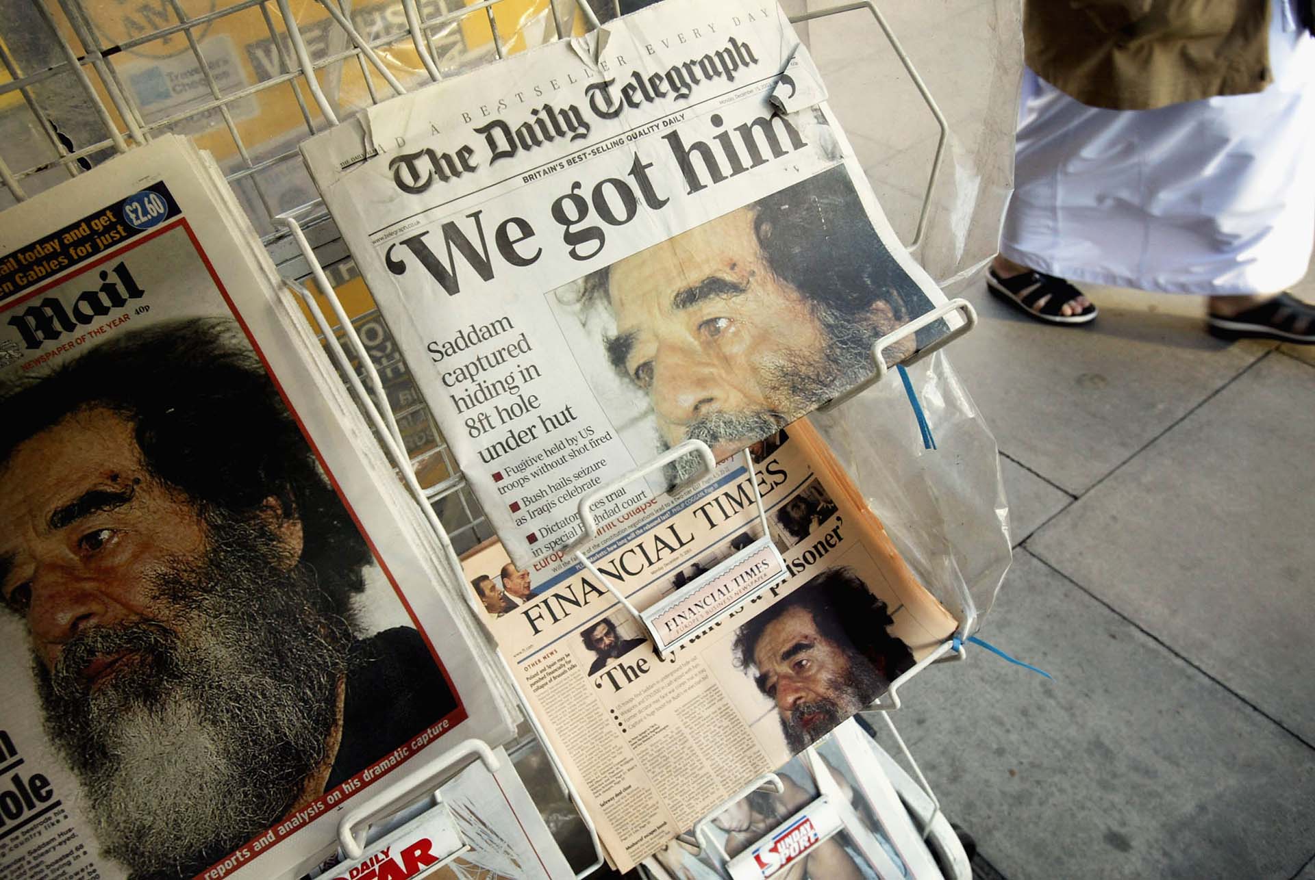  Un quiosco vende periódicos en cuyas portadas se informa de la captura del ex dirigente iraquí Saddam Hussein el 15 de diciembre de 2003 en Londres. Las fuerzas estadounidenses capturaron a Hussein durante una incursión cerca de su ciudad natal de Tikrit el 13 de diciembre. (Foto de Graeme Robertson/Getty Images) 
