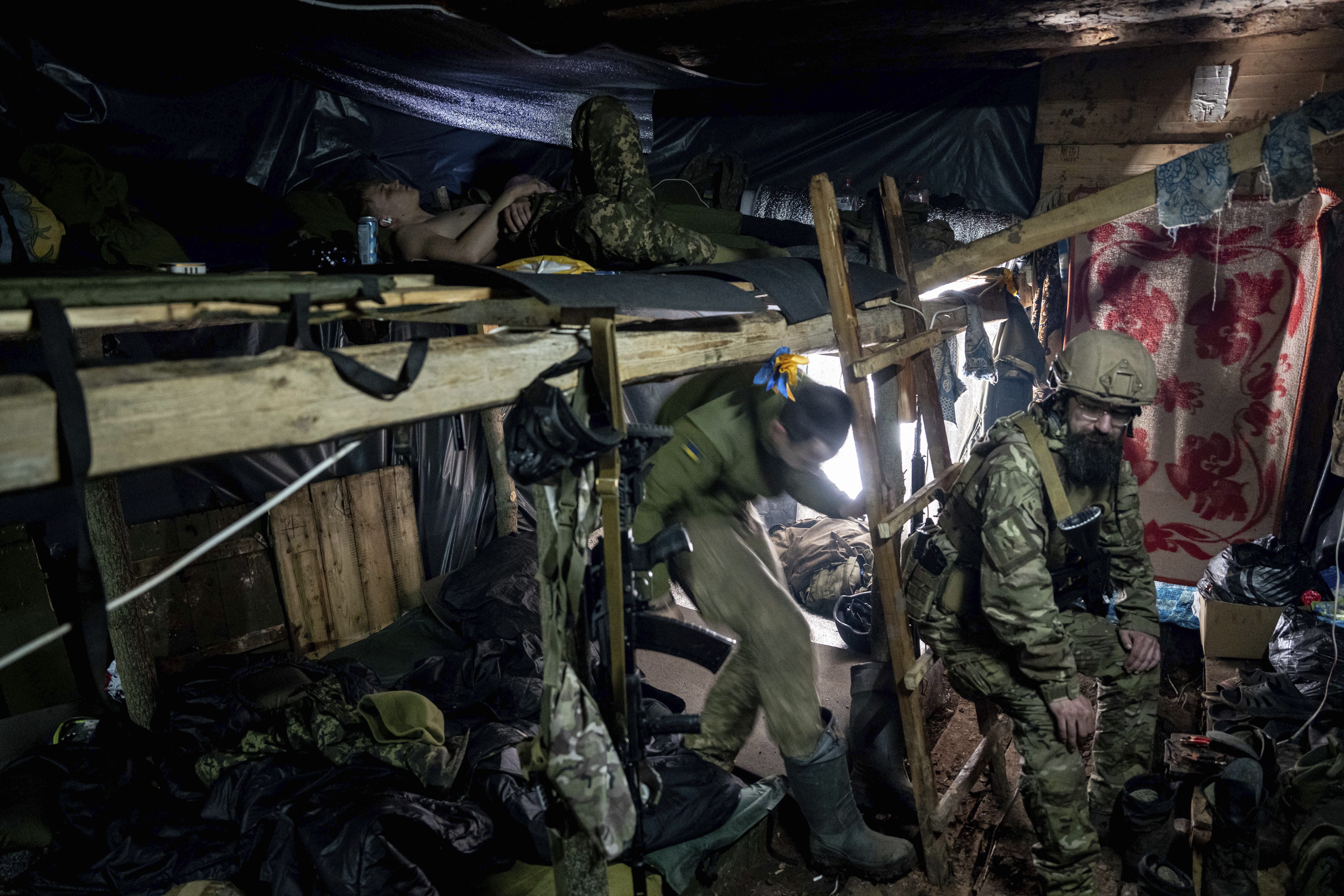 Ukrainian paratroopers from the 80th assault brigade rest inside a trench at the front lines near Bakhmut, Ukraine, on March 10, 2023. (AP Photo/Evgeniy Maloletka)