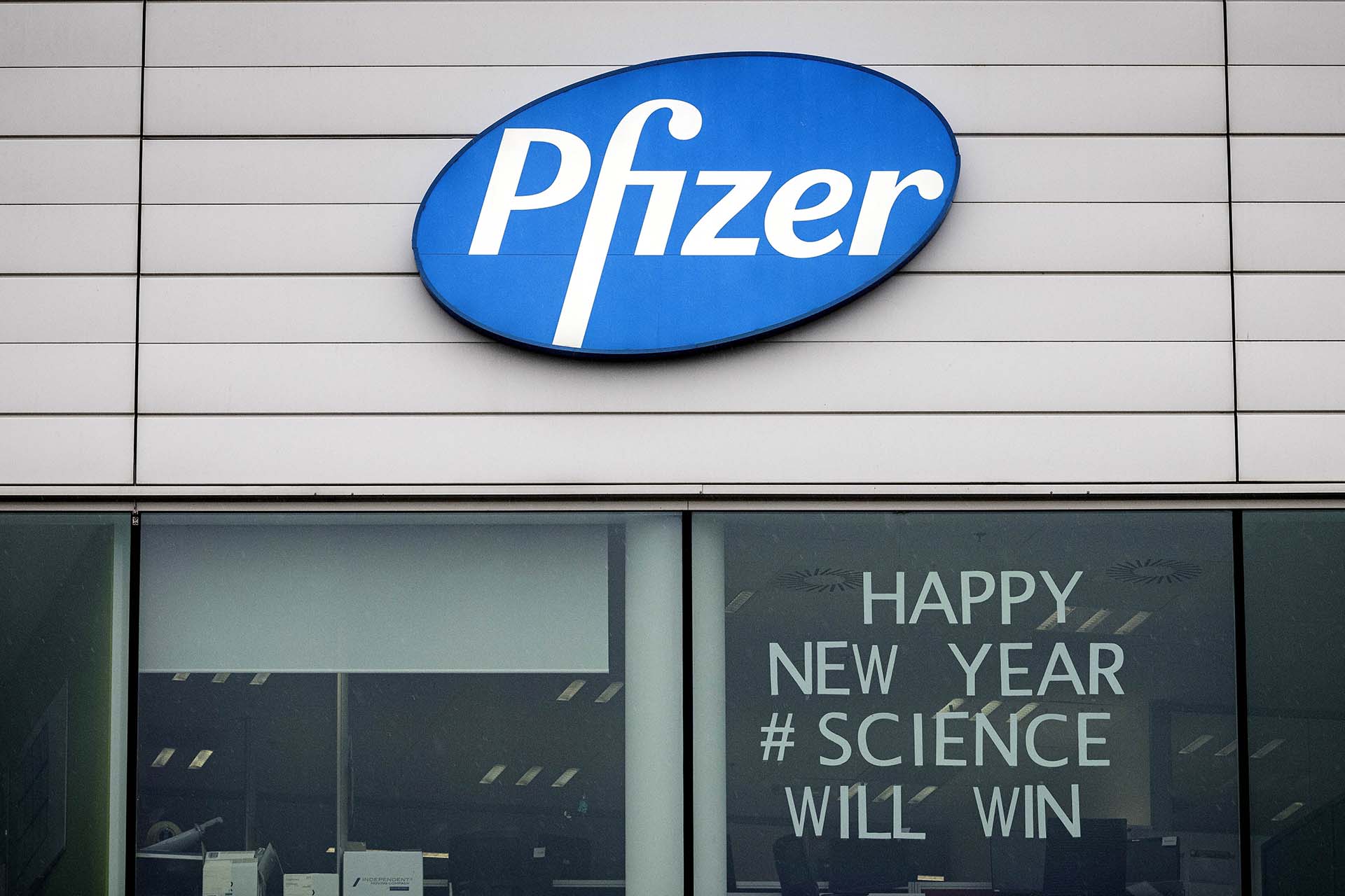 "Feliz año nuevo. La ciencia vencerá", dice el cartel en una ventana del cuartel central de Pfizer en Puurs, Bélgica. 