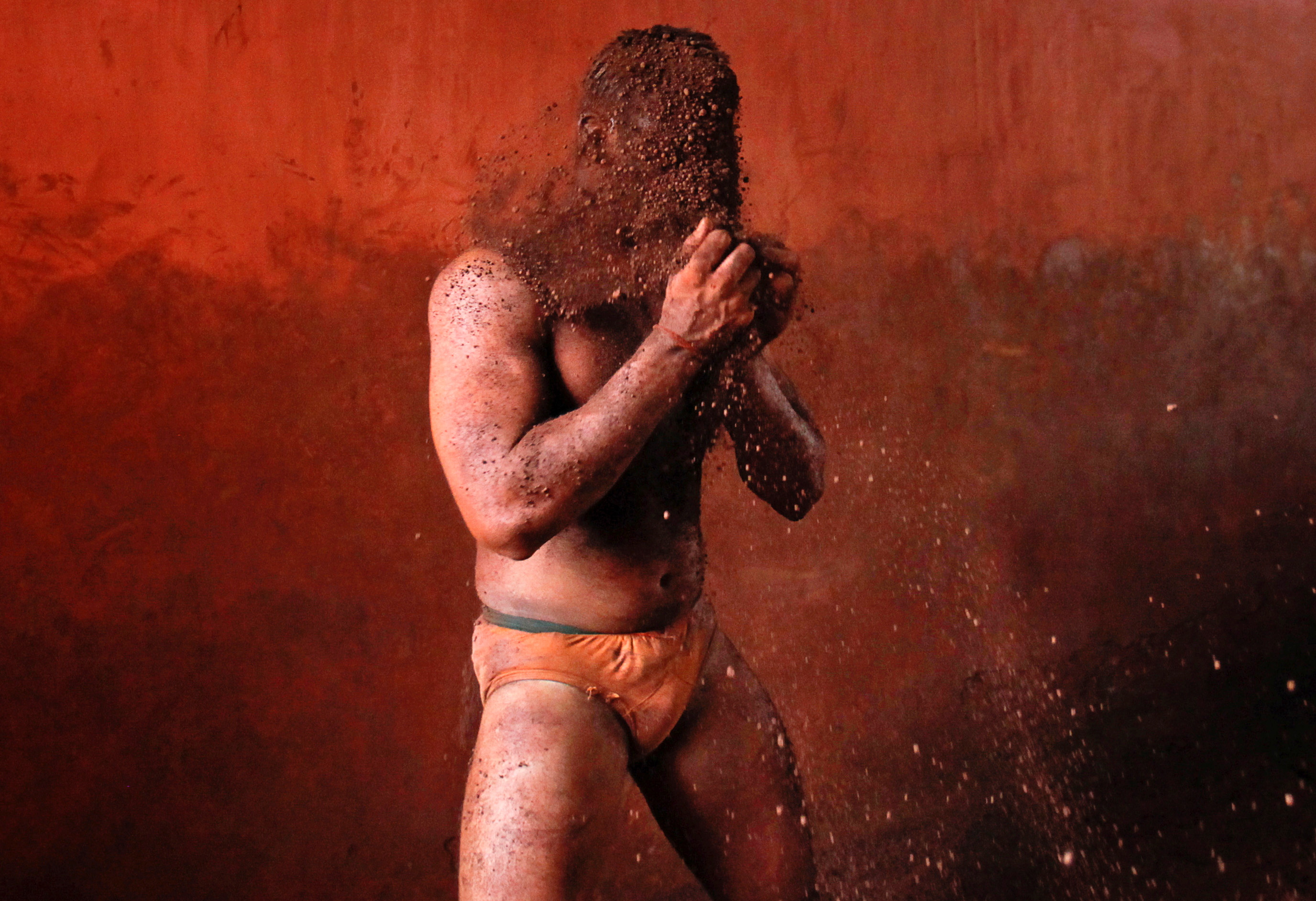 Un luchador se frota las manos con barro para evitar resbalar debido al sudor, durante un combate tradicional de lucha en el barro (Kushti) en el centro Akhaara en Kolhapur, a unos 400 kms al sur de Mumbai.