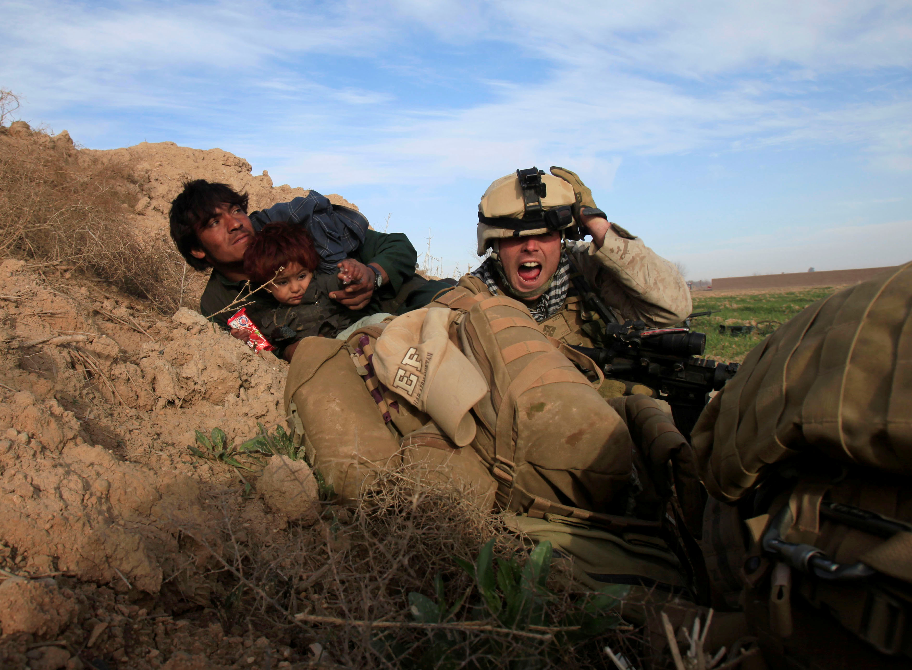 Chris Sanderson, de 24 años, de Flemington, Nueva Jersey, de la Marina de los EE. UU., grita mientras intenta proteger a un afgano y a su hijo después de que combatientes talibanes abrieran fuego en la ciudad de Marjah, en el distrito de Nad Ali, provincia de Helmand, Afganistán, febrero 13, 2010. (REUTERS / Goran Tomasevic / Foto de archivo)