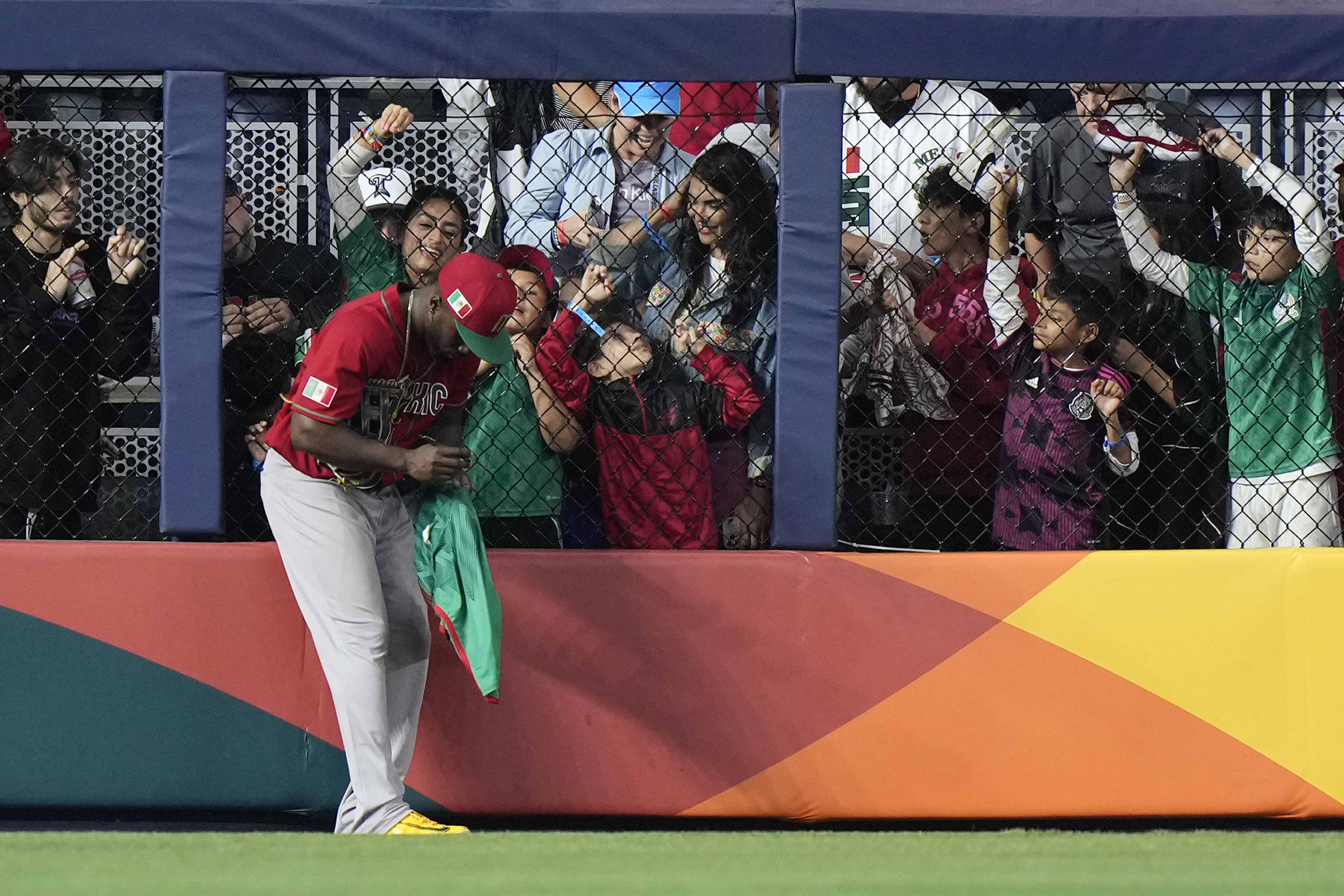 El jardinero izquierdo de México Randy Arozarena firma autógrafos durante un cambio de lanzadores en el séptimo inning de la semifinal contra Japón en el Clásico Mundial de béisbol, el lunes 20 de marzo de 2023, en Miami. (AP Foto/Wilfredo Lee)