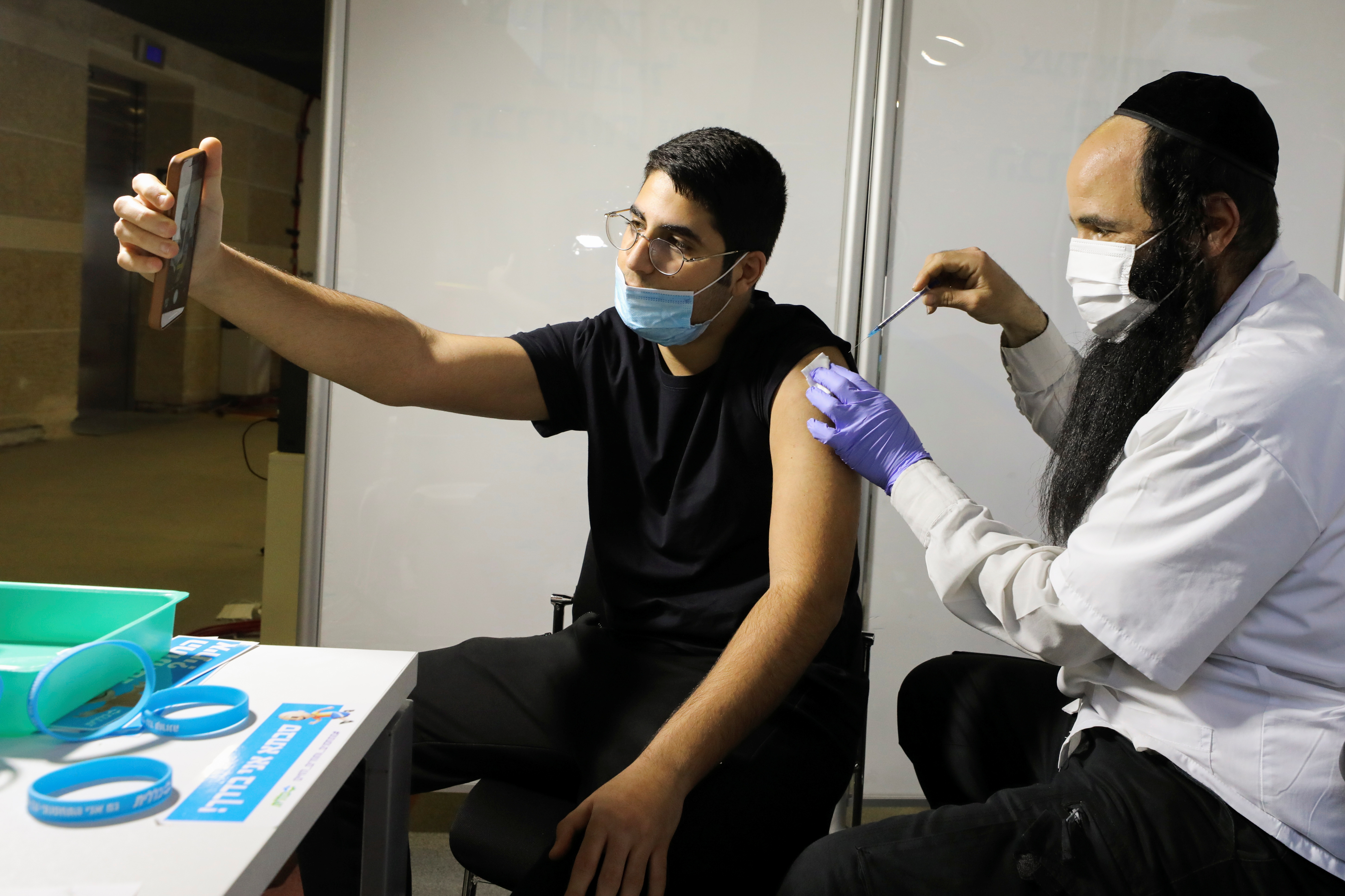 Un hombre recibe una vacuna contra la enfermedad del coronavirus (COVID-19) en un centro de vacunación temporal de la organización de mantenimiento de la salud (HMO) de Clalit, en un estadio deportivo en Jerusalén el 25 de febrero de 2021. Foto tomada el 25 de febrero de 2021. REUTERS/Ammar Awad