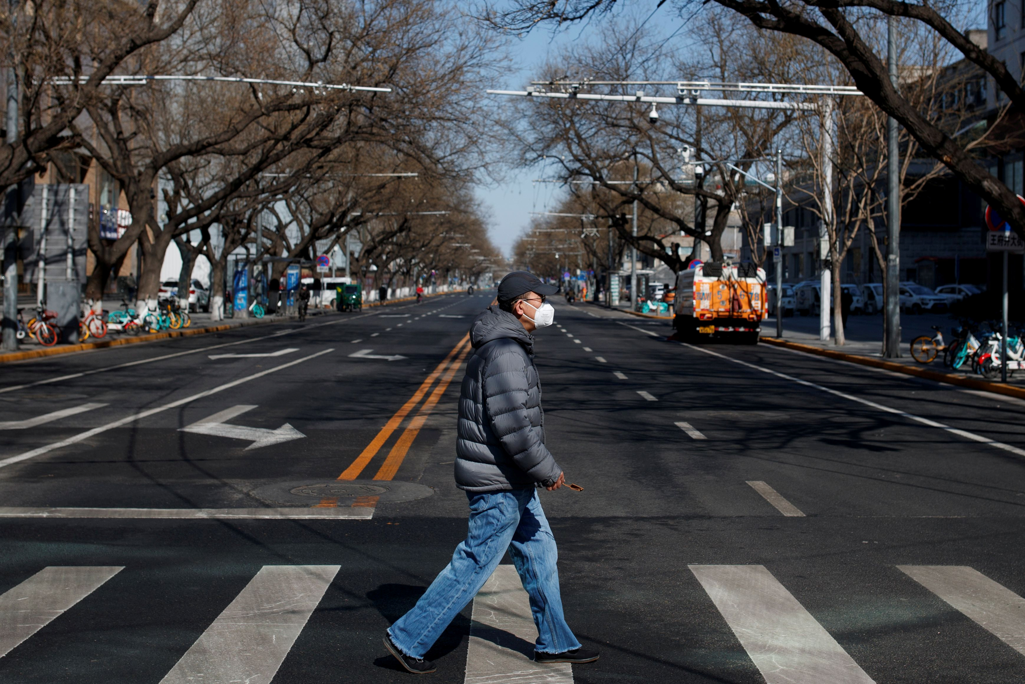 Un hombre cruzando una calle en Beijing, utilizando un barbijo (REUTERS/Thomas Peter/File Photo)