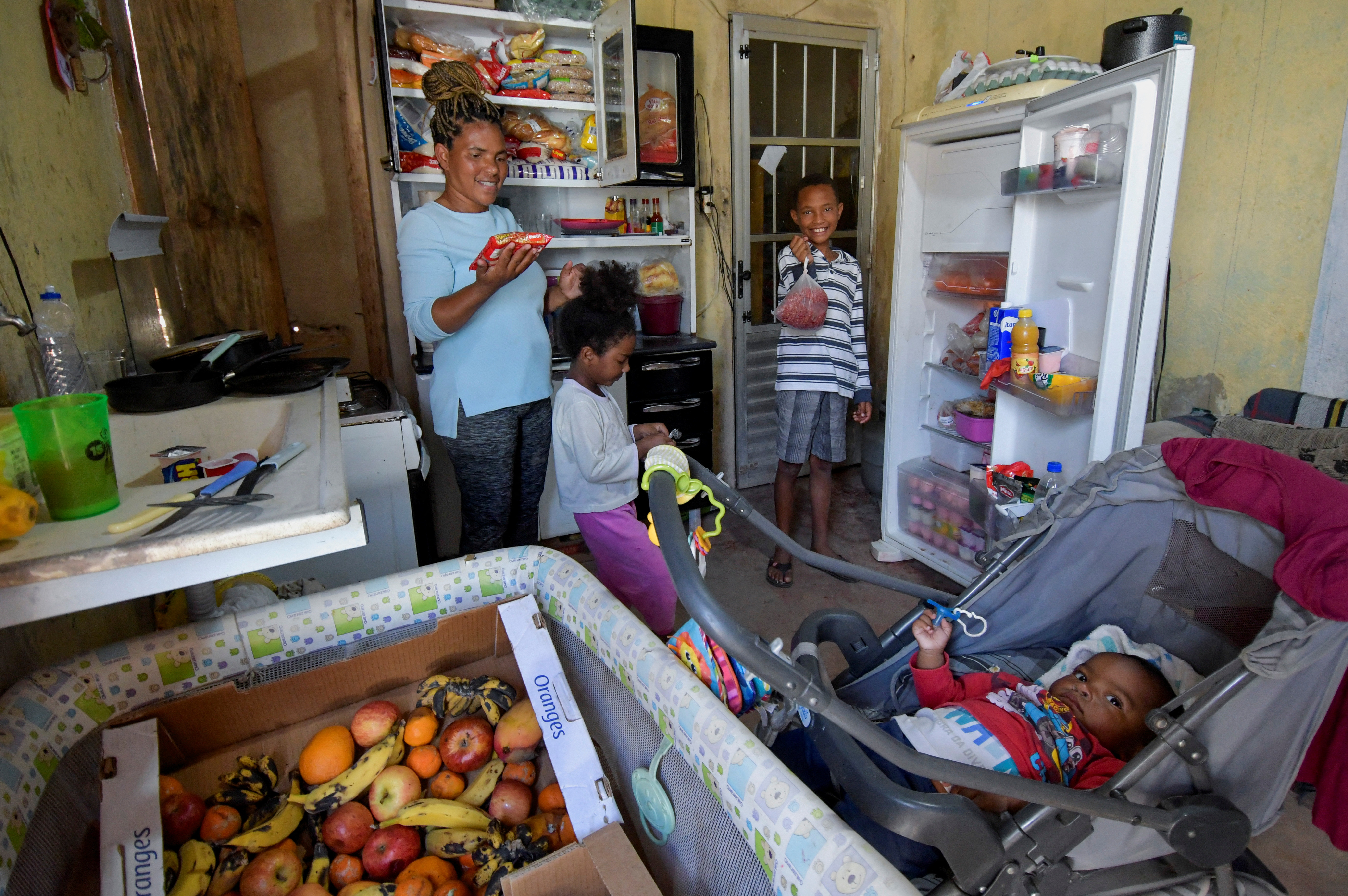 La familia es retratada en su casa con los alimentos que recibió (REUTERS/Washington Alves)