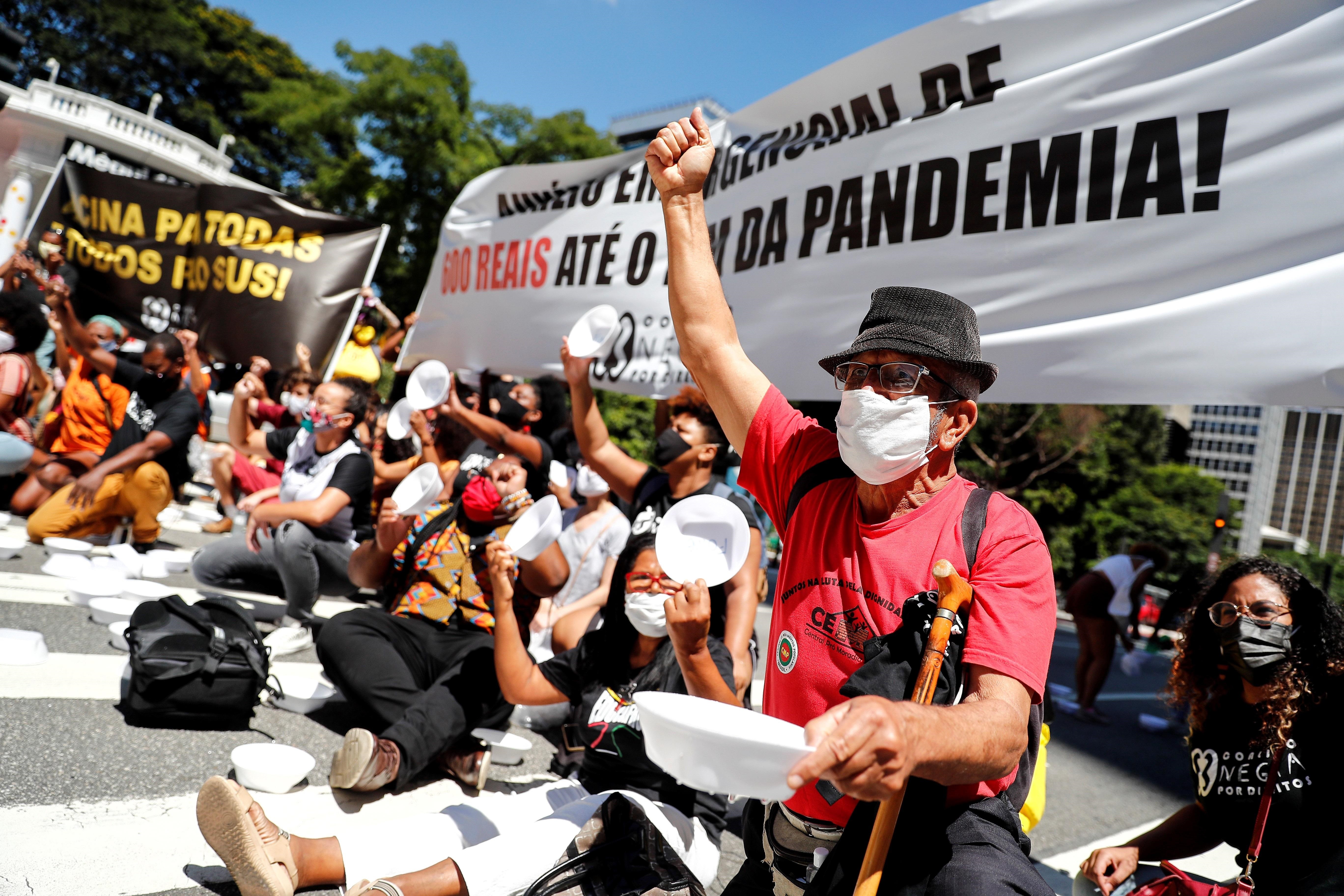 Integrantes de la Coalición Negra Por Derechos, alianza compuesta por más de 200 movimientos sociales y afro, participan hoy en una manifestación con platos vacíos frente a la sede del Banco Central de Brasil, en la avenida Paulista, en Sao Paulo (Brasil). EFE/ Sebastiao Moreira