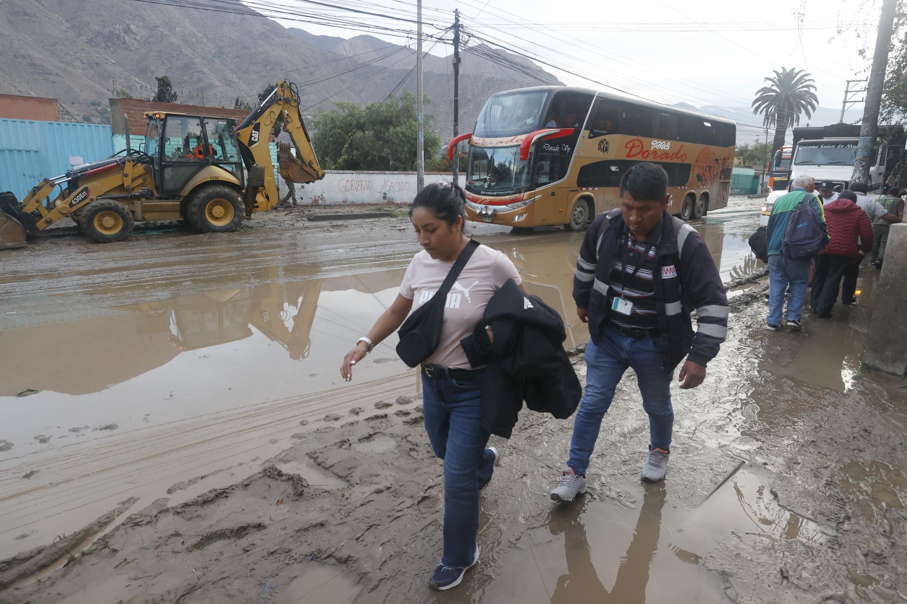 Las personas han tenido que transitar sobre el barro para poder llegar a sus destinos sin verse afectados por estos deslizamientos. (Andina)