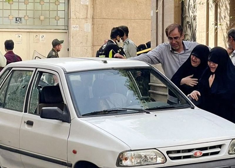 Los familiares del coronel Sayad Khodai, miembro del Cuerpo de Guardias de la Revolución Islámica de Irán, lloran sobre su cuerpo en su coche después del asesinato (Agencia de Noticias de Asia Occidental/via REUTERS)