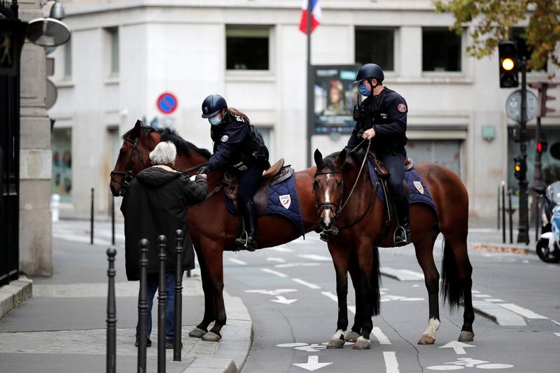 Oficiales de policía a caballo realizan un control a un transeúnte en la avenida Champs-Elysee, en París