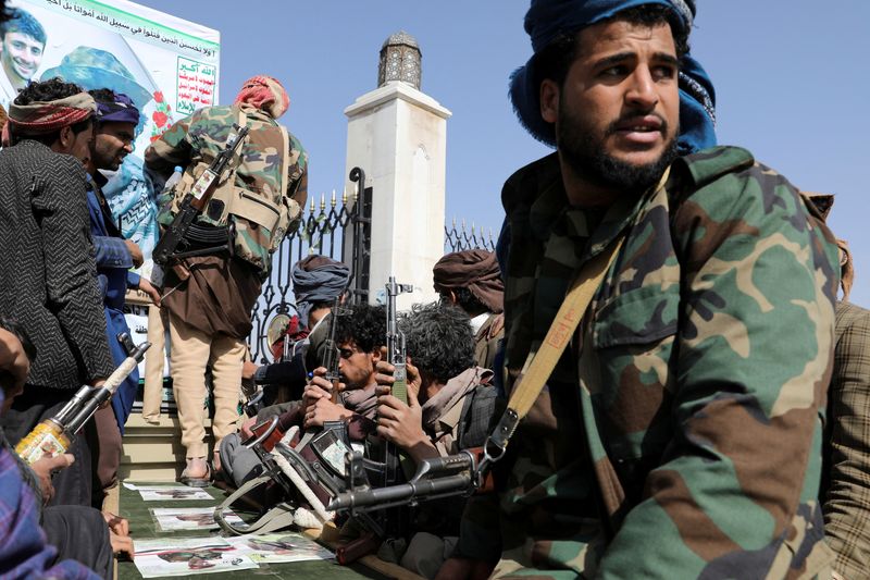 FOTO DE ARCHIVO: Miembros armados del movimiento hutí sentados junto al féretro de un hutí asesinado en un enfrentamiento contra fuerzas gubernamentales yemeníes en Saná, Yemen, el 20 de febrero de 2021. REUTERS/Khaled Abdullah