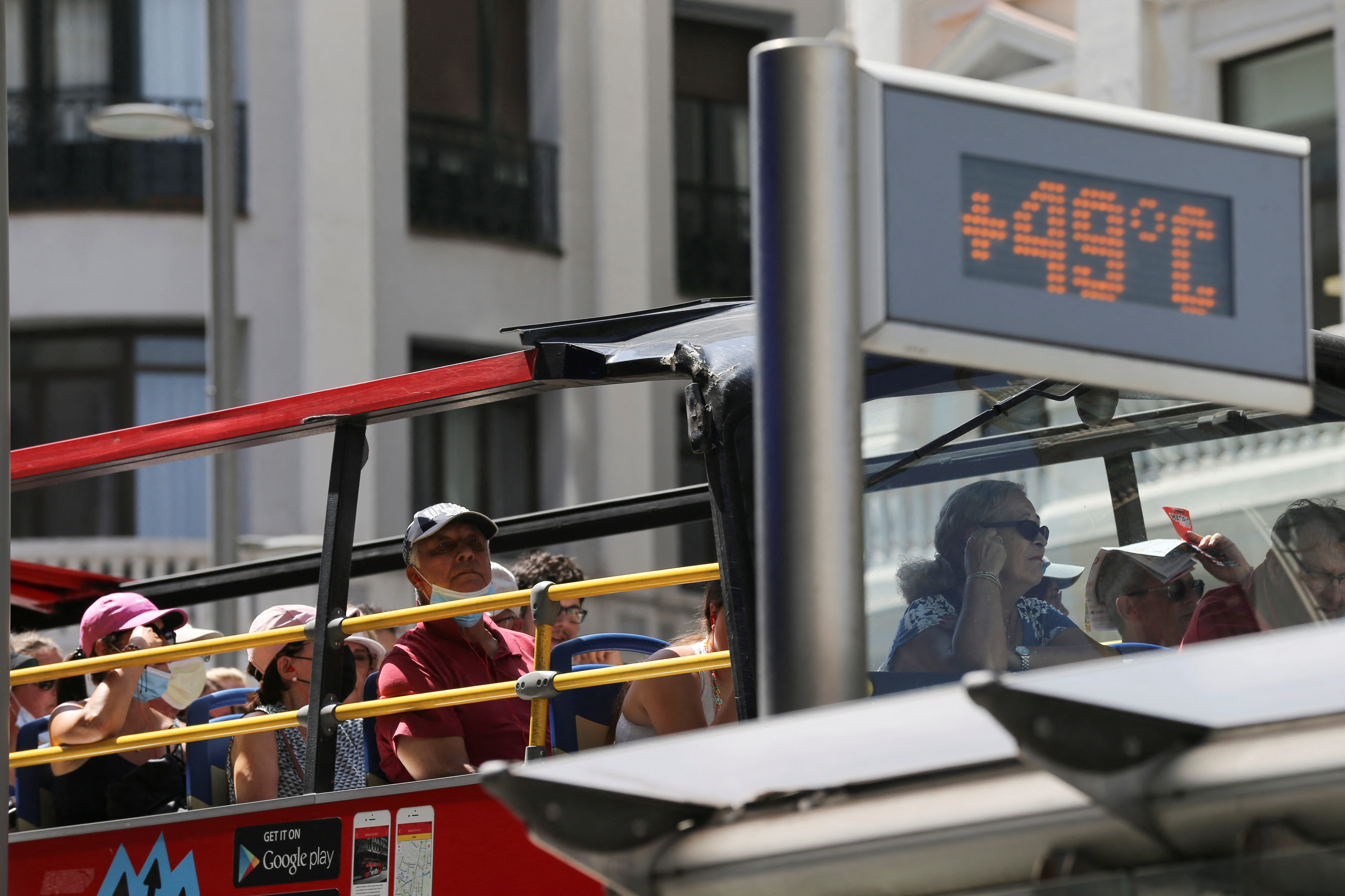 Un micro con turistas pasa detrás de un termómetro que muestra la temperatura alarmante en Madrid (REUTERS/Isabel Infantes)