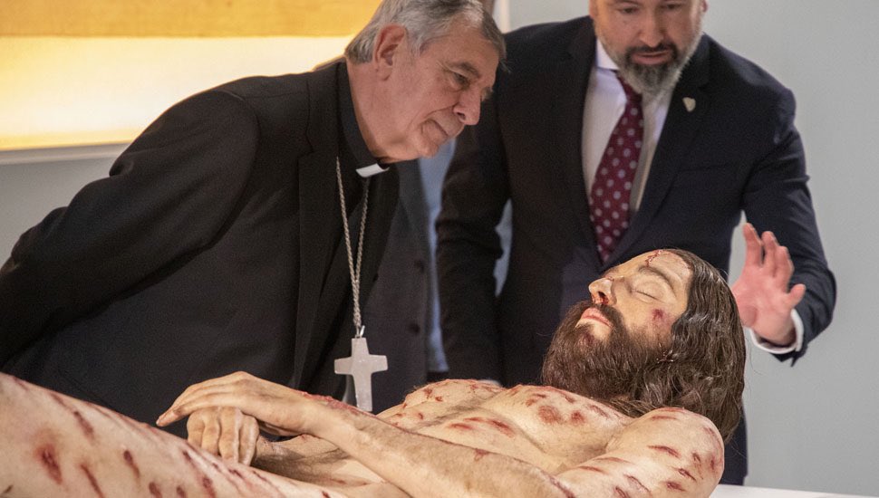 Monseñor José Luis Retama observando el cuerpo hiperrealista de Jesucristo (Twitter: @UniCatolicos_es)