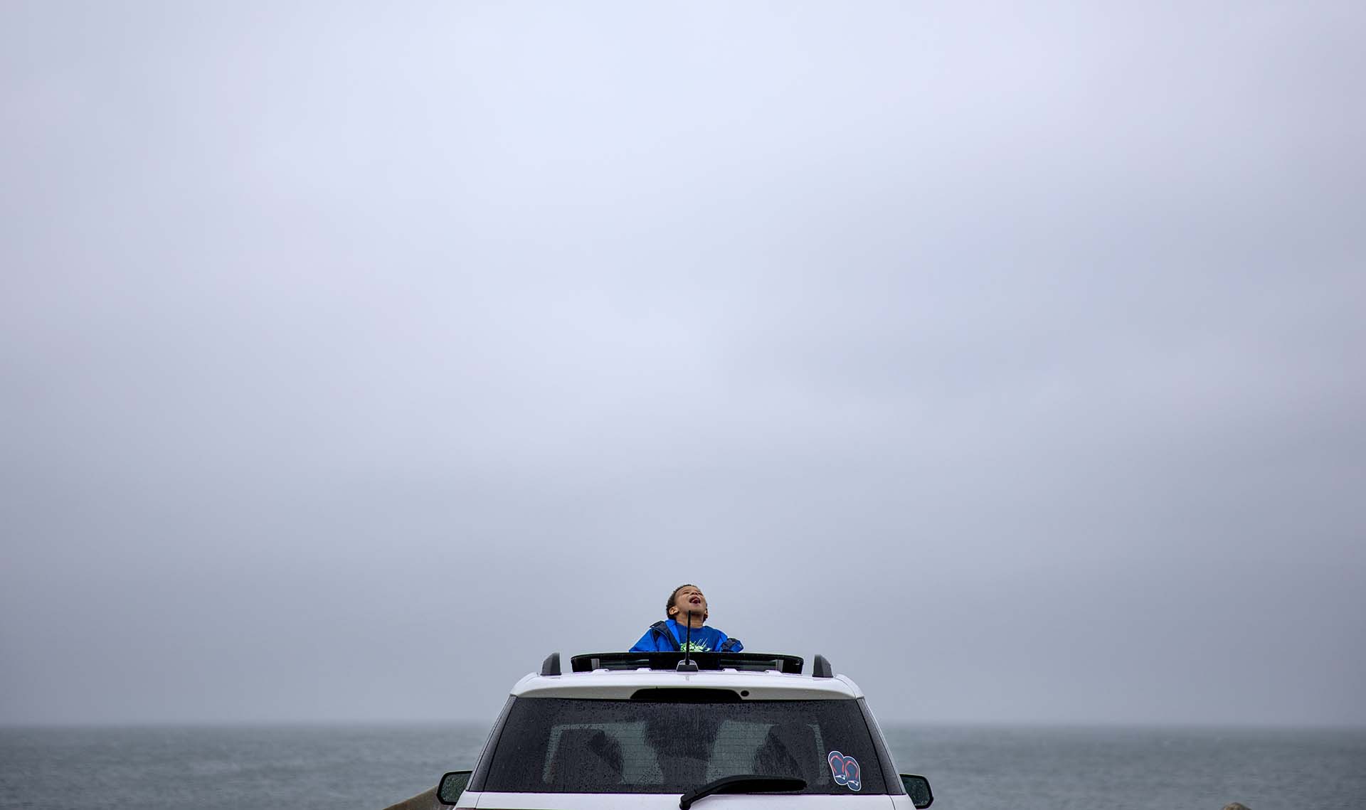 Mason Lambert, de 5 años, mira al cielo mientras la lluvia cae en Narragansett, Rhode Island (AP Photo/David Goldman)