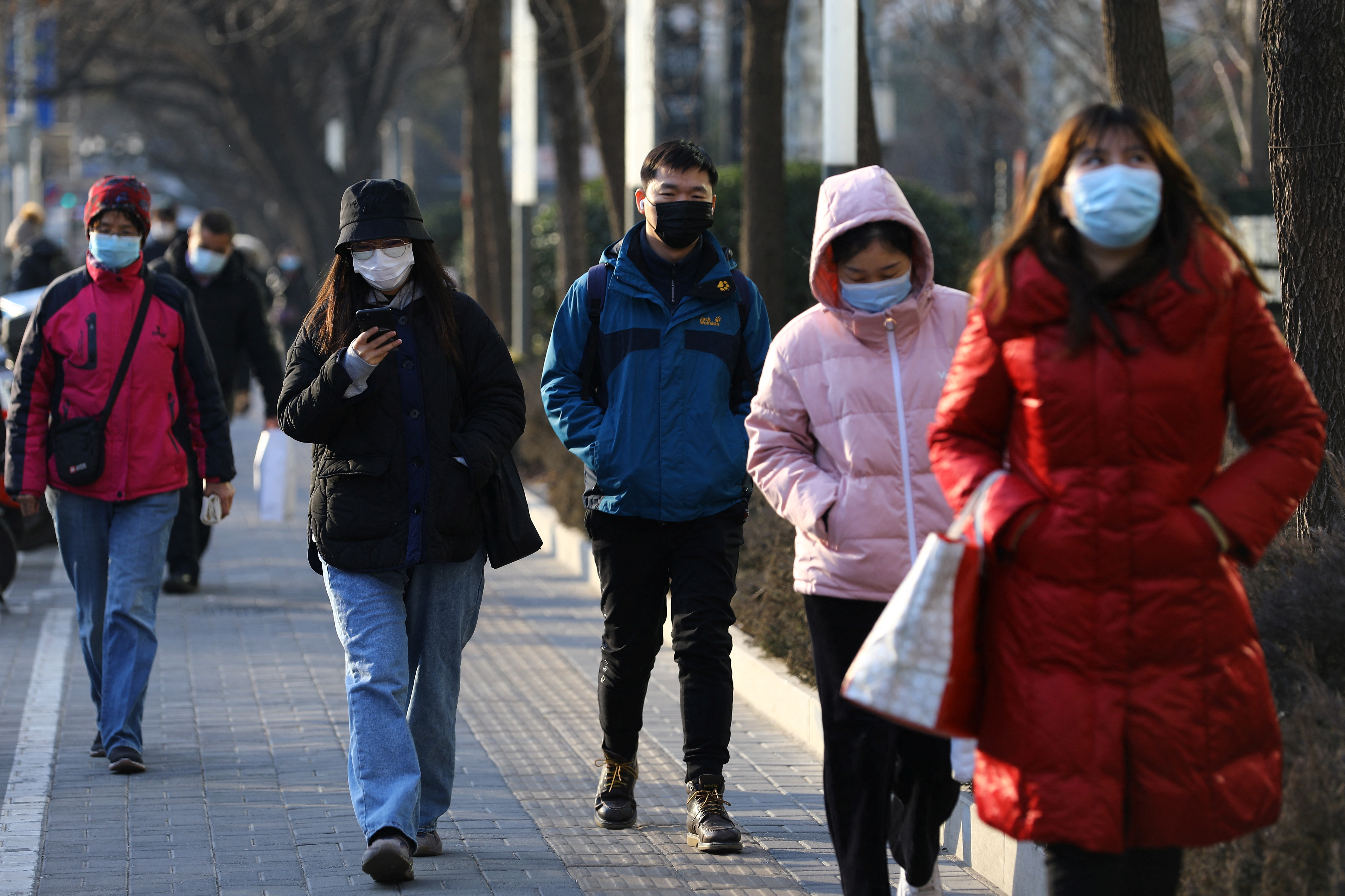 Personas caminan con mascarillas en China 