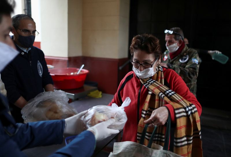 Una mujer recibe pan en un comedor de la iglesia durante el brote de coronavirus en Buenos Aires (REUTERS/Agustin Marcarian)
