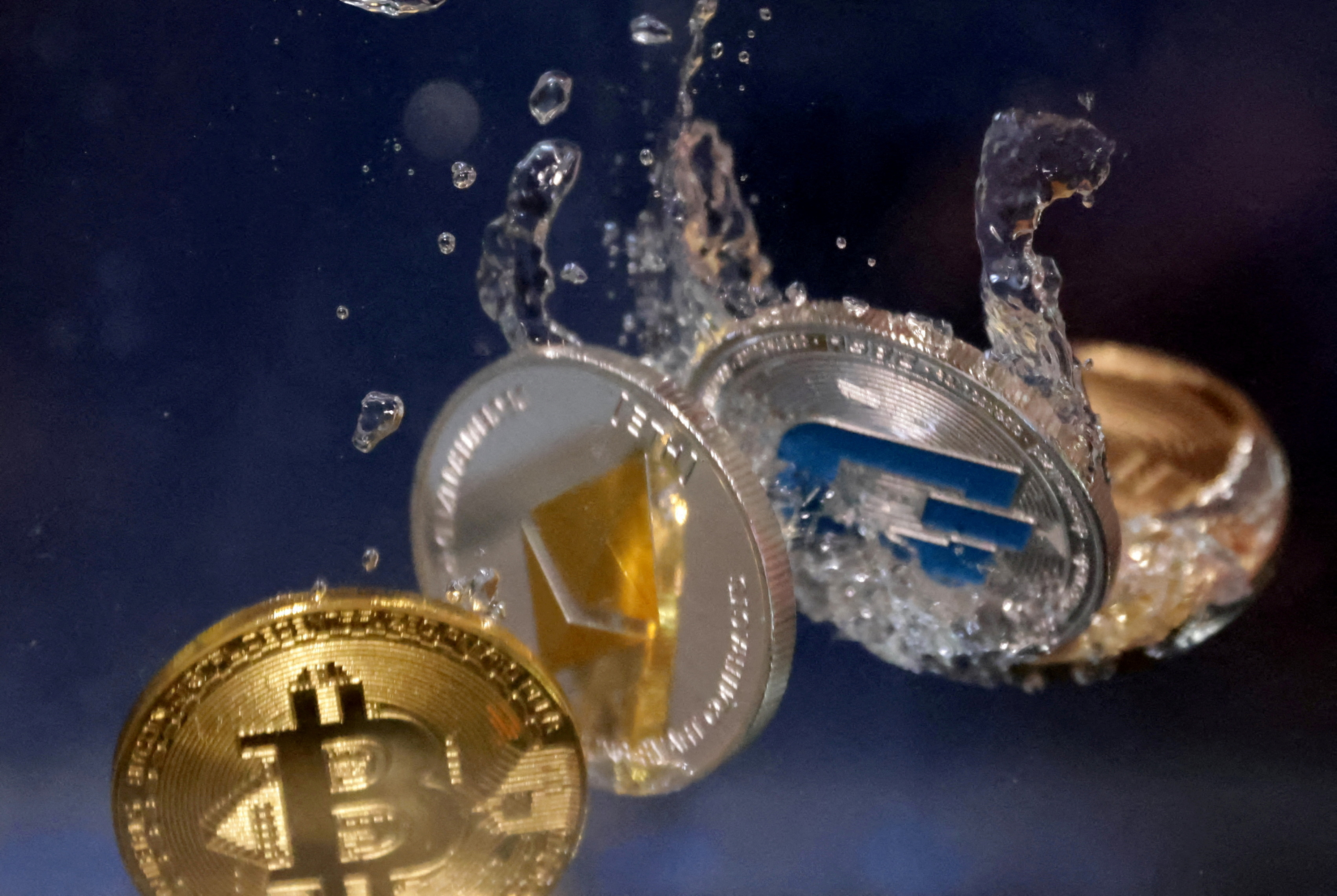 FILE PHOTO: Representations of cryptocurrency Bitcoin, Ethereum and Dash plunge into water in this illustration taken, May 23, 2022. REUTERS/Dado Ruvic/File Photo