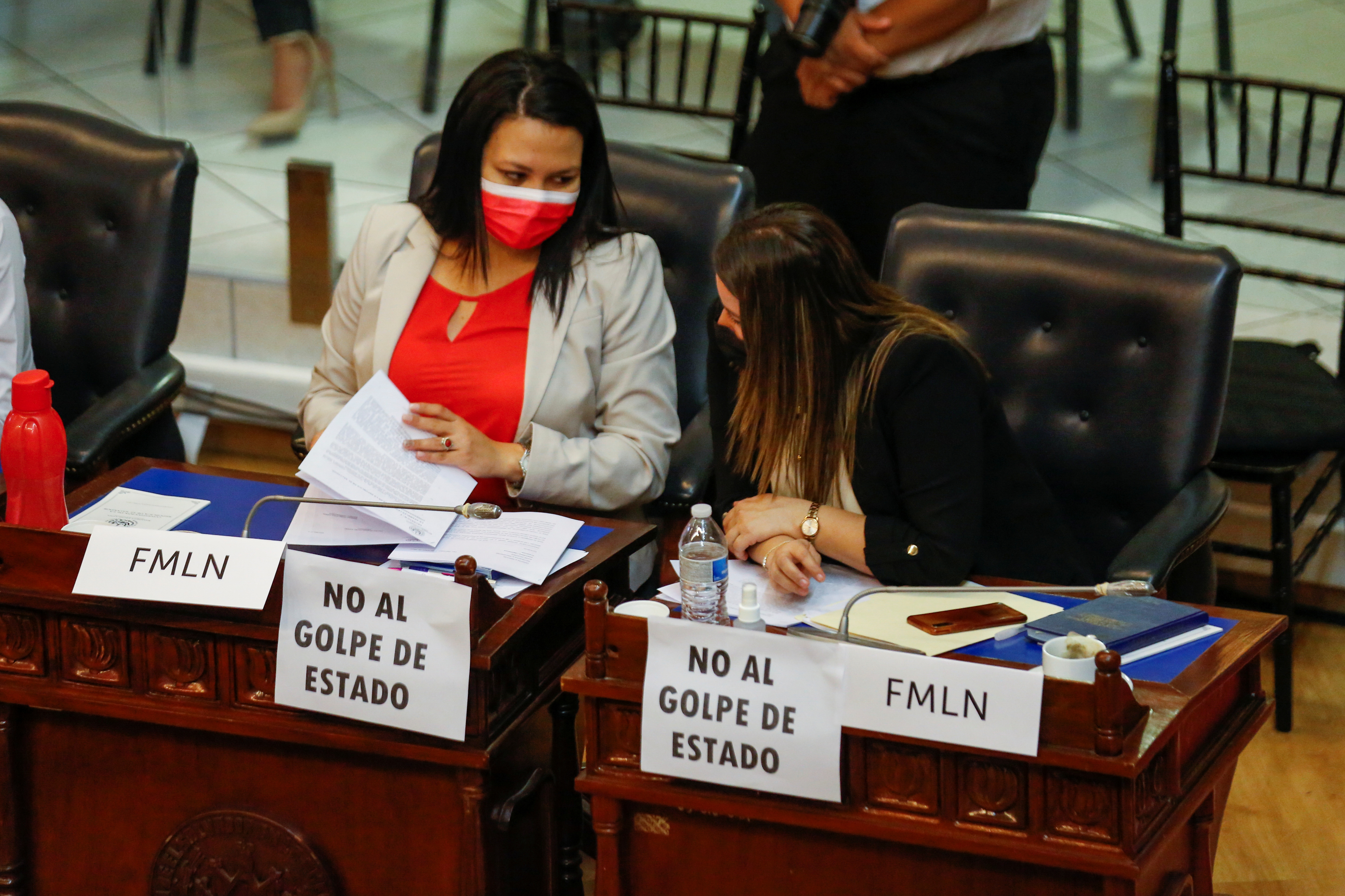 Representantes de la oposición muestran pancartas en las que se leía "No al golpe de Estado", mientras participan en una sesión para discutir la destitución de magistrados de la Corte Suprema en el Congreso salvadoreño, en San Salvador, El Salvador, el 1 de mayo de 2021. REUTERS/Jose Cabezas