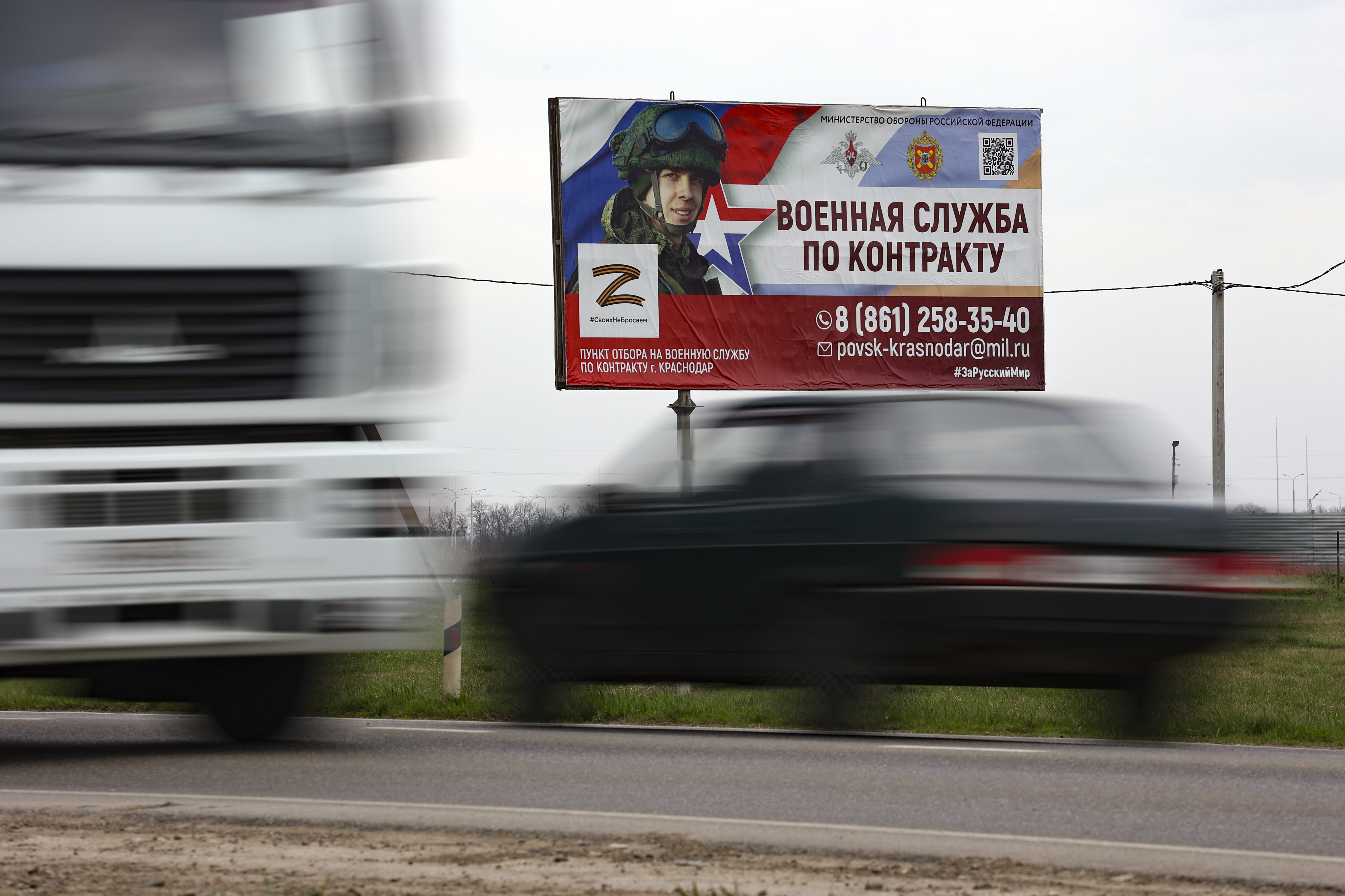 Un cartel que anuncia un "contrato de servicio militar" se ve junto a una autopista a las afueras de Krasnodar en la nueva campaña de reclutamiento (AP)