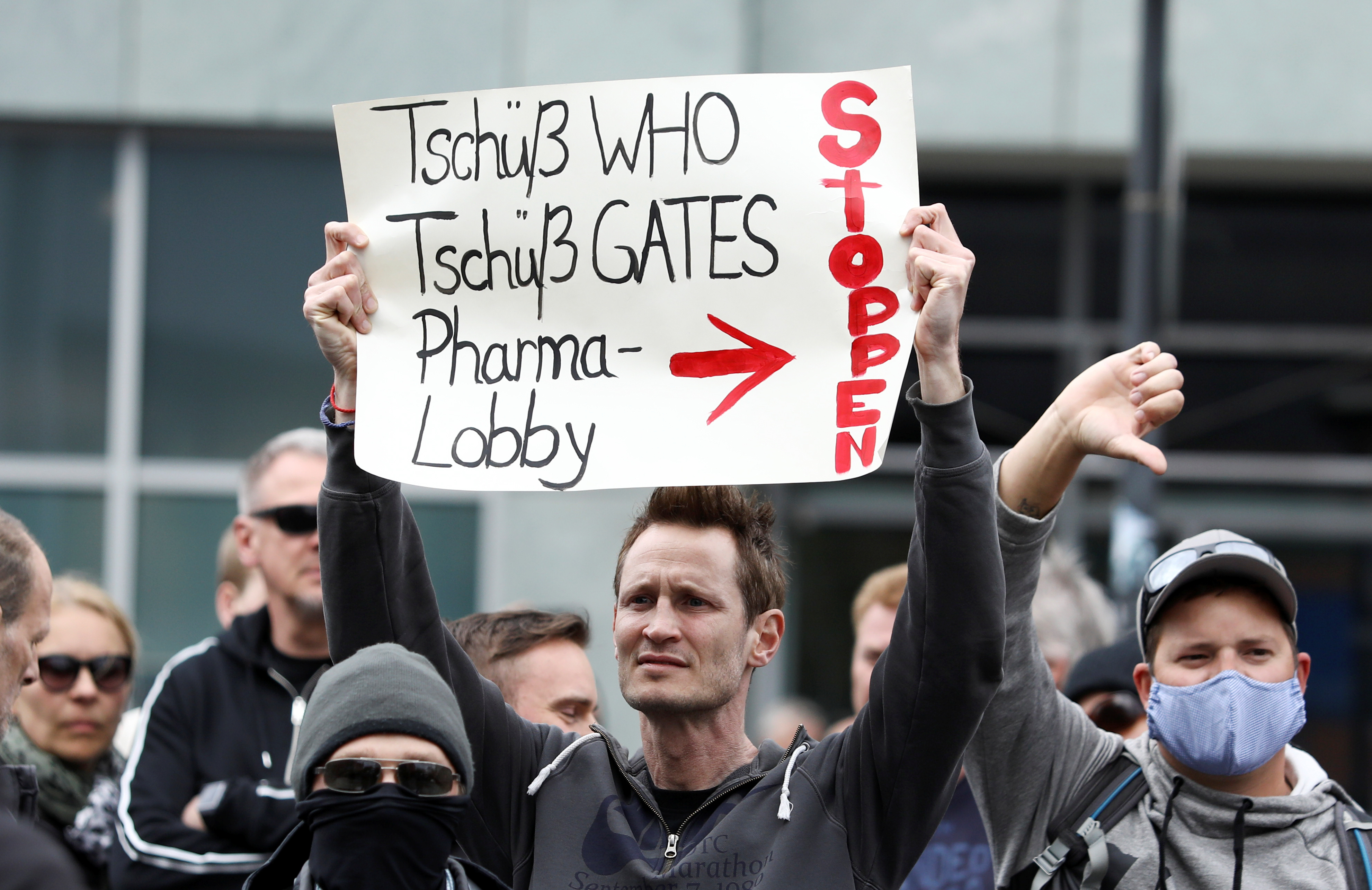 Un manifestante de grupos de ultraderecha, en Berlín, que se oponen a la cuarentena, muestra una pancarta contra la OMS, Billa Gates y las empresas farmacéuticas. REUTERS/Christian Mang