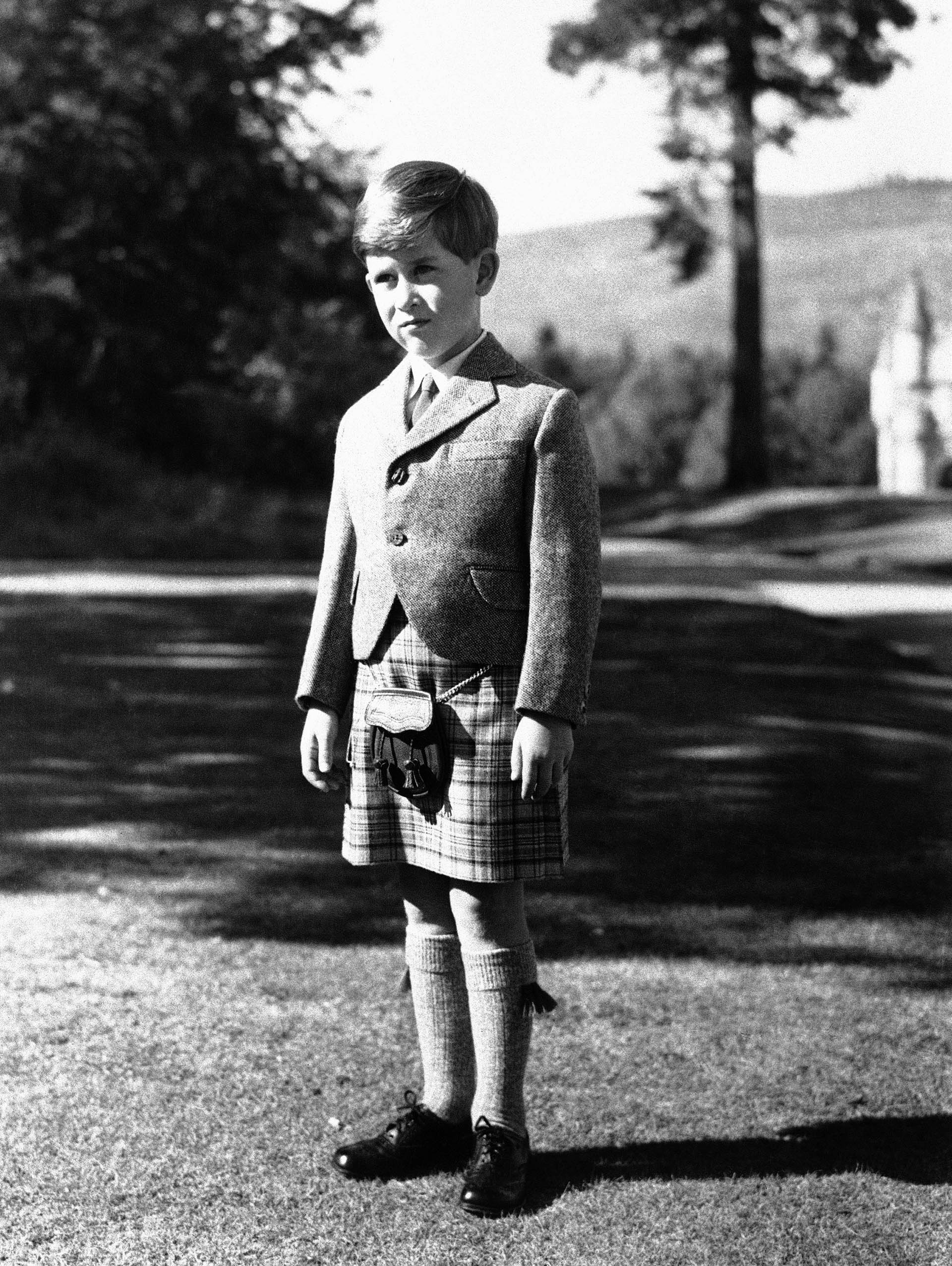 ARCHIVO - El príncipe Carlos de Gran Bretaña posa para una foto con una falda escocesa de Balmoral Tartan en los terrenos del Castillo de Balmoral, en Balmoral, Escocia, el 12 de noviembre de 1955.  (Foto AP, Archivo)
